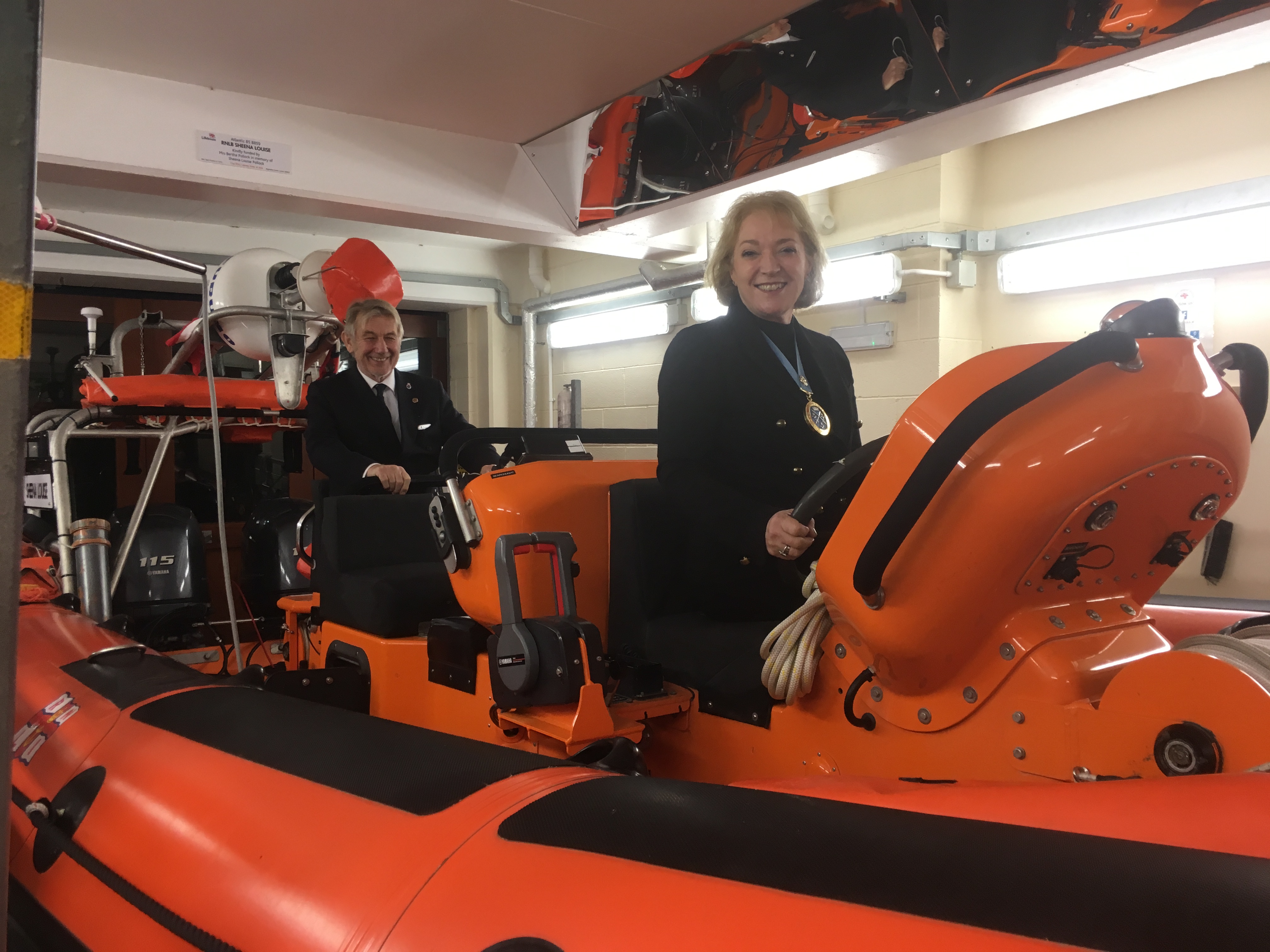 The High Sheriff at the helm of the lifeboat with husband Richard taking a crew role.