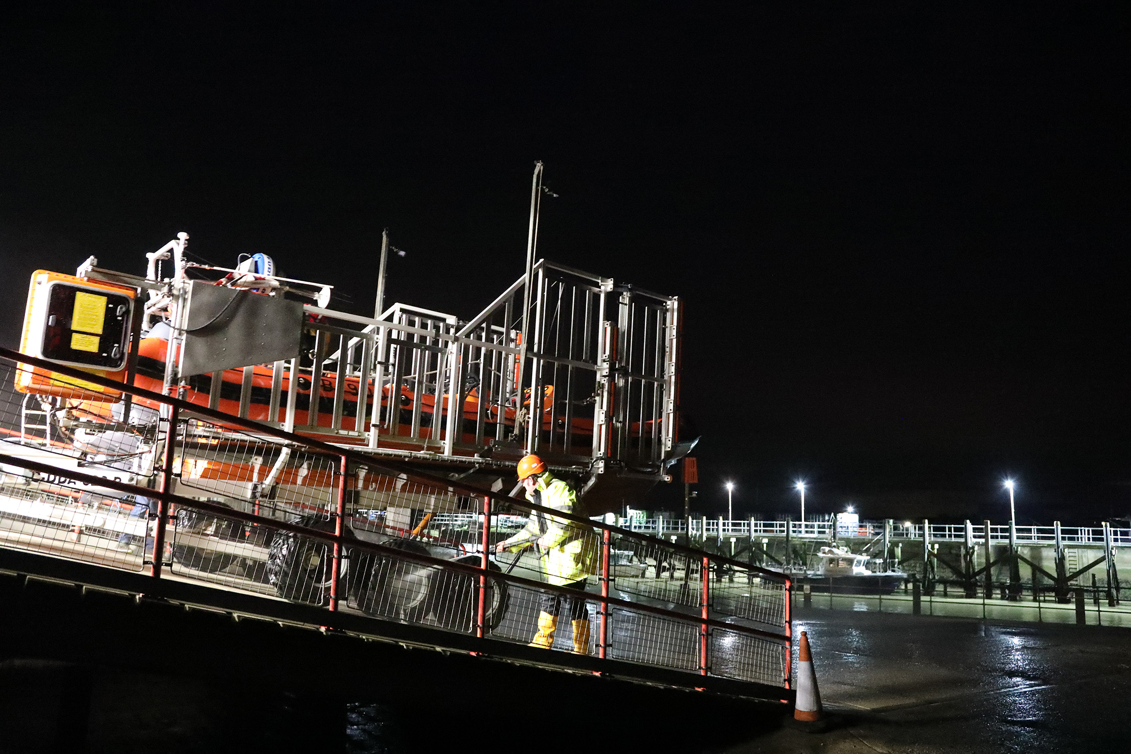 In the darkness the returning lifeboat is hosed down by one of the crew
