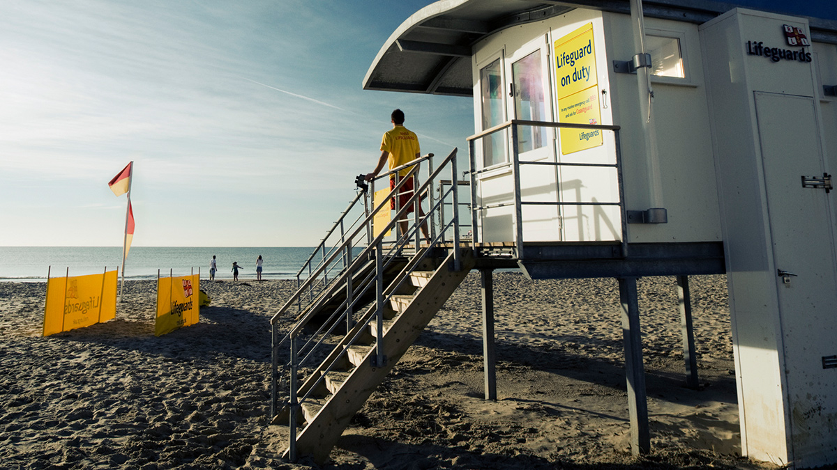 Lifeguard standing on the steps of beach office