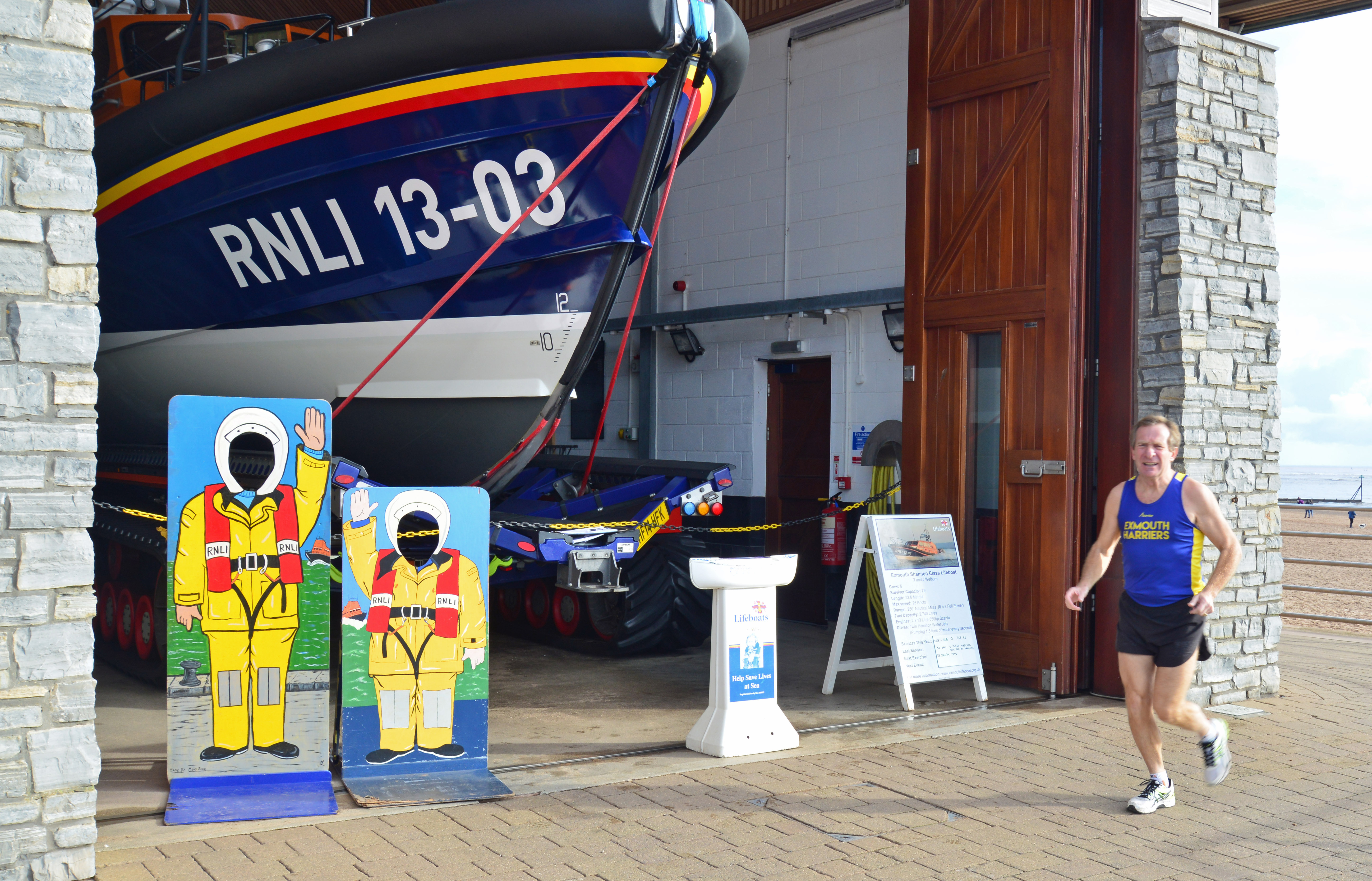 Veteran runner and volunteer Tour Guide, Des White running past Exmouth Lifeboat Station