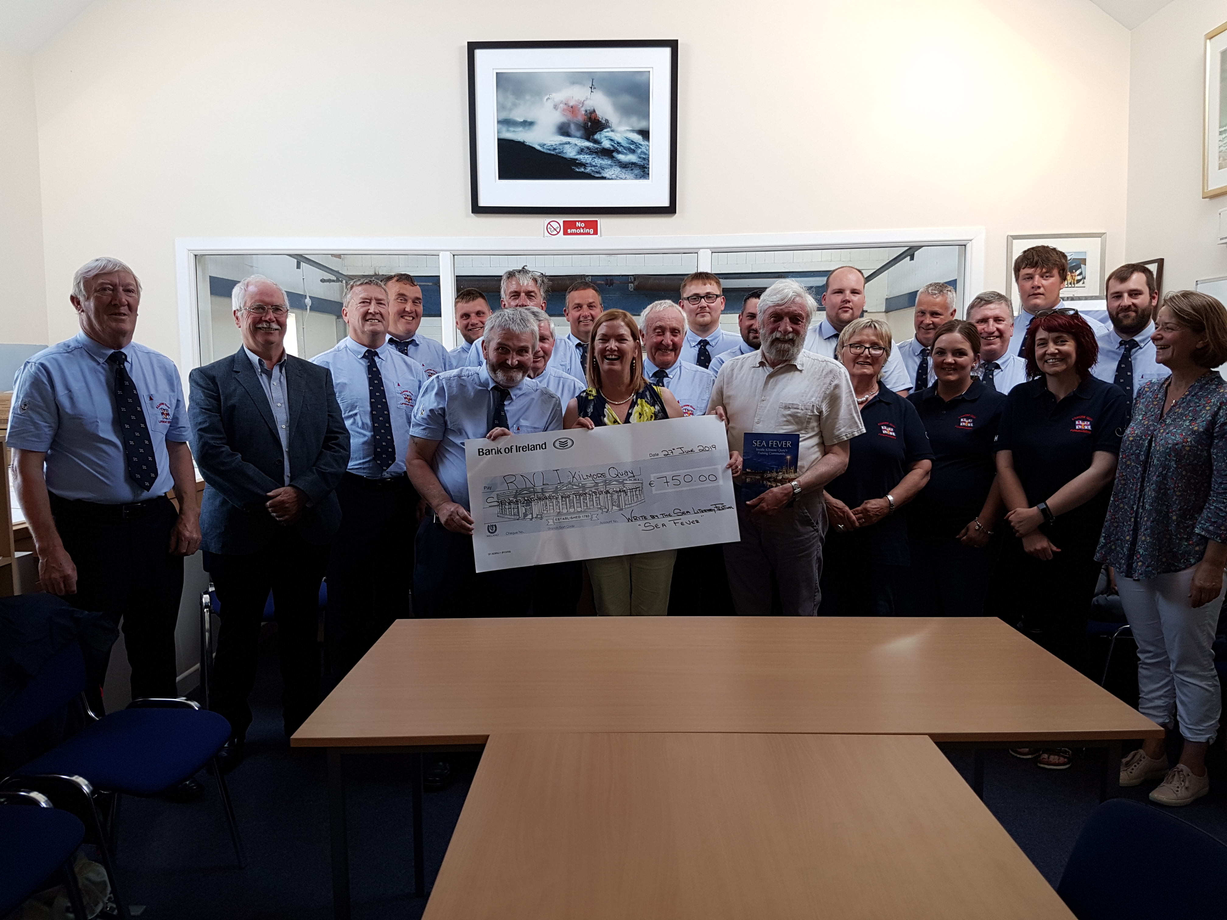 Presenting the cheque to Fundraising chairperson Johnny Moore is Write by the sea Chairperson Lucy Moore, Jackie Hayden (Author); Derek Burke (Committee Write be the Sea); Sylvia Kehoe (Treasurer Write by the Sea) at Kilmore Quay lifeboat station.