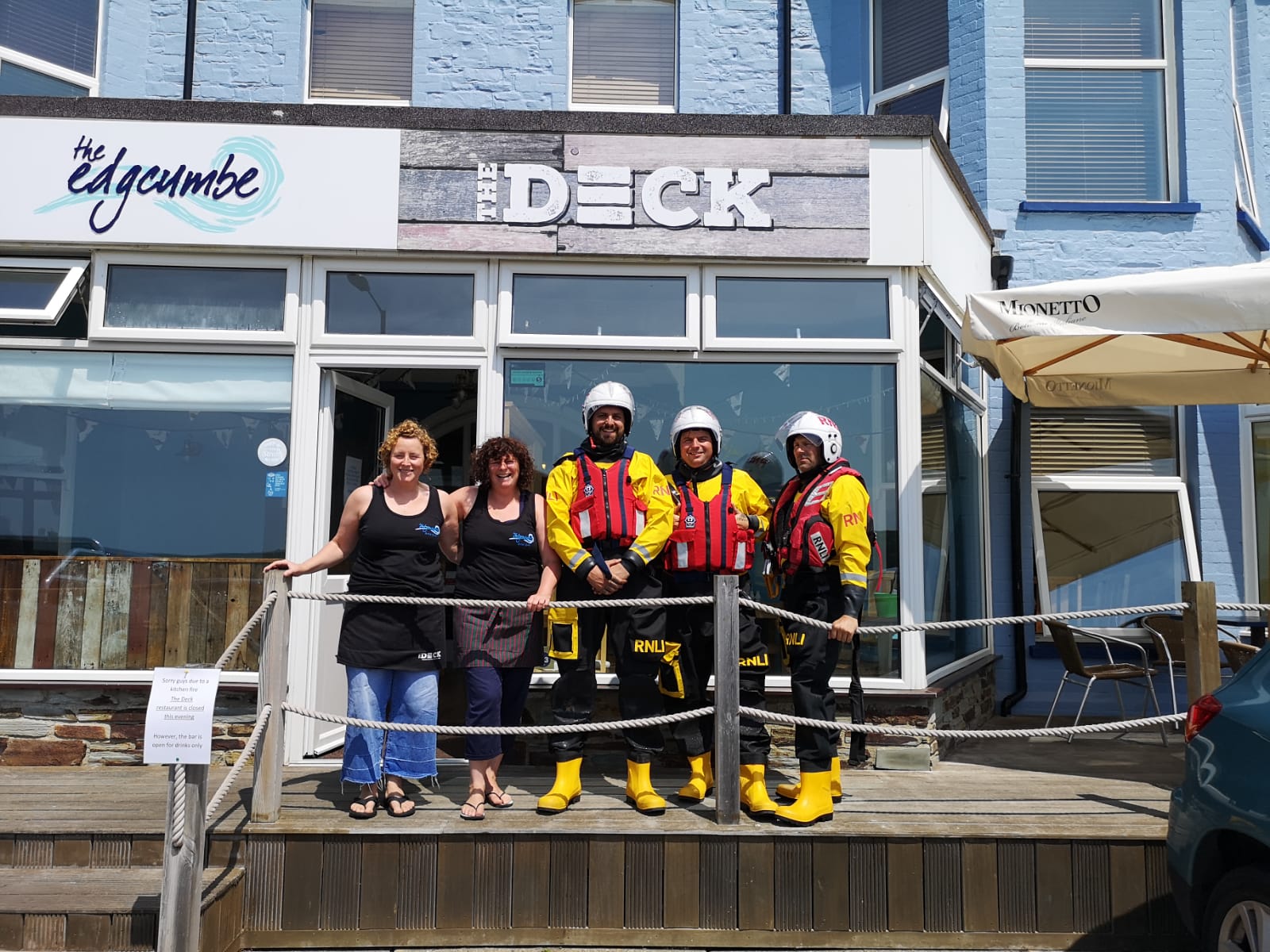 Two members of The Deck bar and restaurant staff with three volunteer crew members from RNLI Bude Lifeboat
