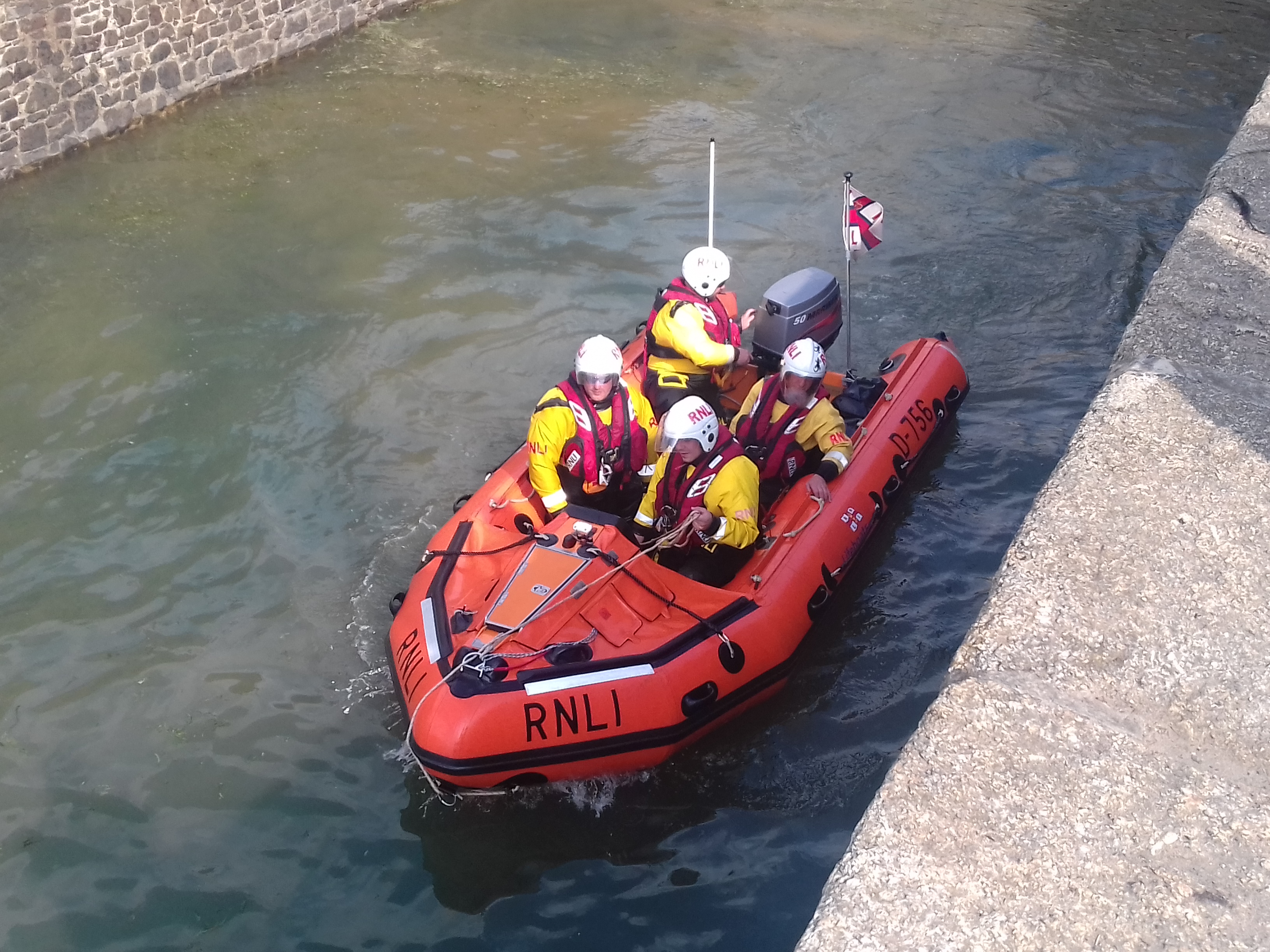 RNLI volunteer lifeboat crew and D class inshore lifeboat George Bird arriving for the Blessing of the Sea service at the lock gates.