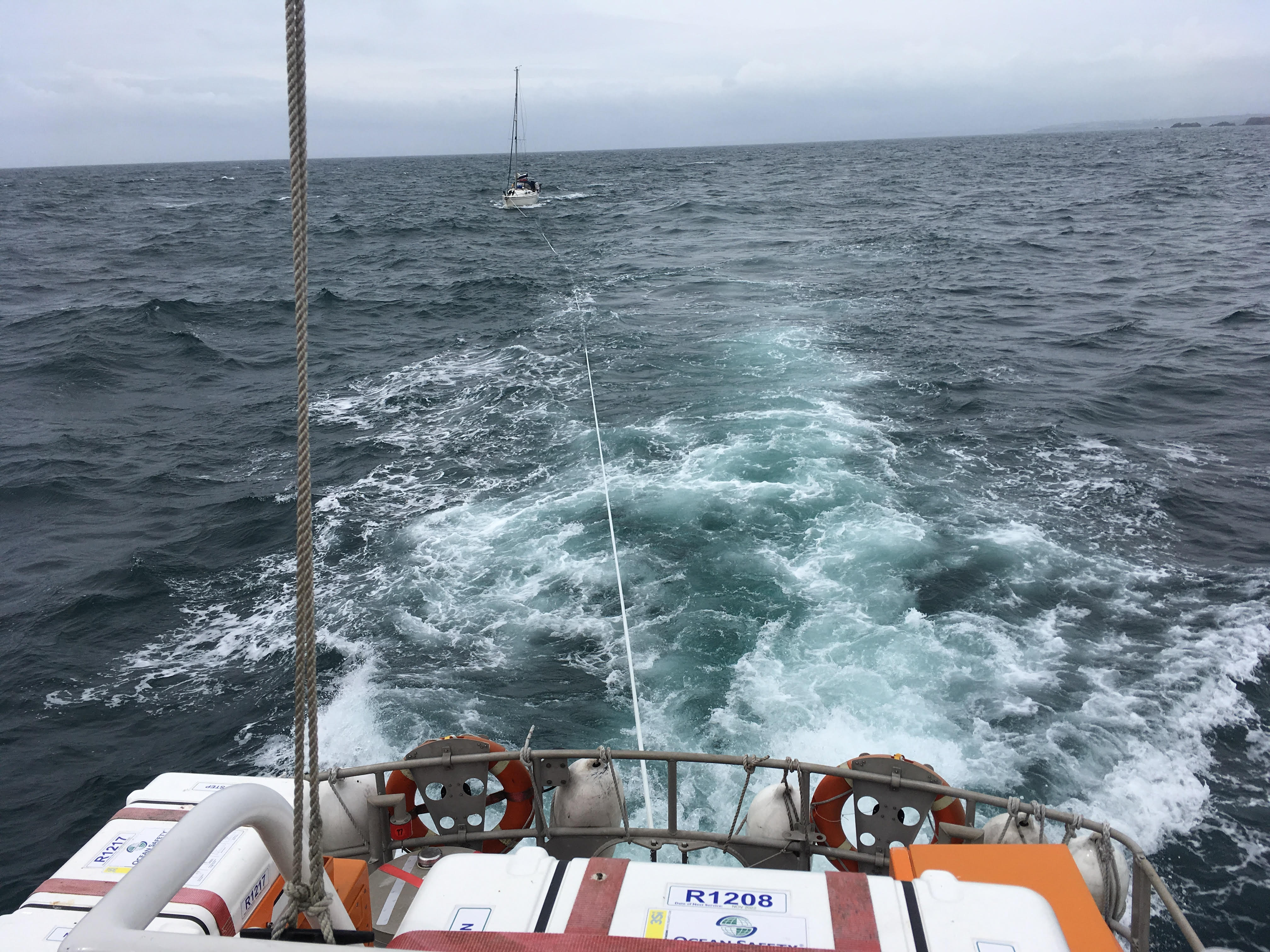 Yacht being towed by lifeboat