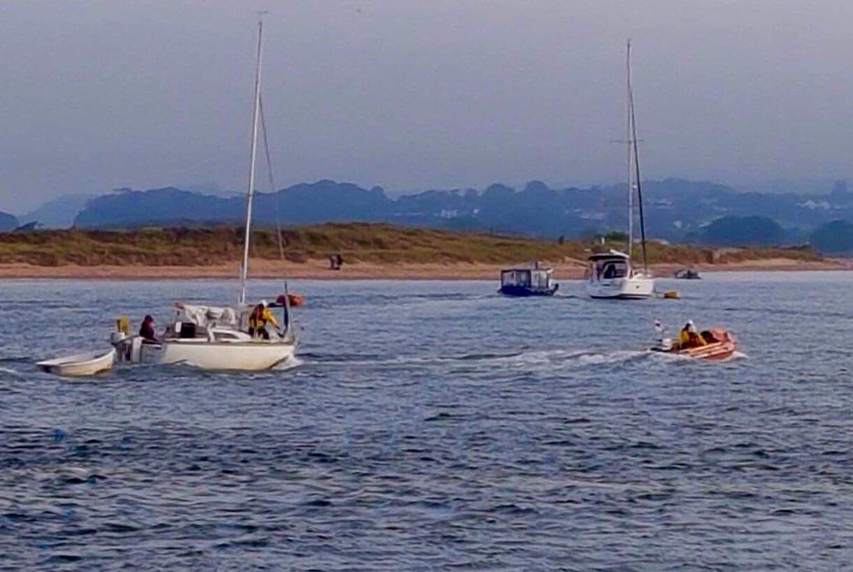 Inshore D class lifeboat George Bearman II towing small yacht into river Exe
