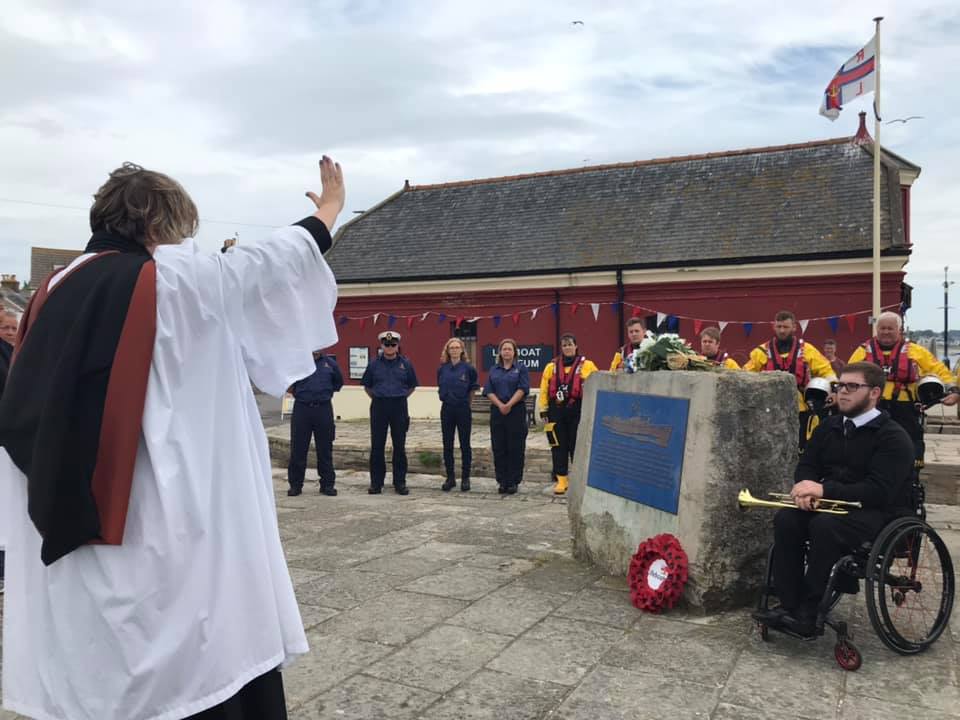 Reverend Lucy Holt leading a commeartive service with Harry Bassett who played the Last Post
