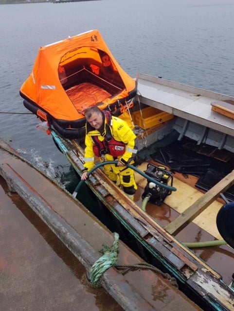 Volunteer crew member Hamish Hunter pumping water from the Scottie's Pride