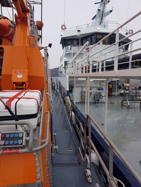 Salmon well boat Ronja Carrier alongside RNLI Aith's Charles Lidbury