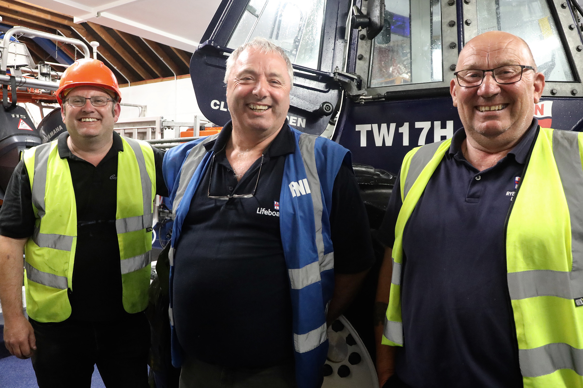 three RNLI members in the boat house
