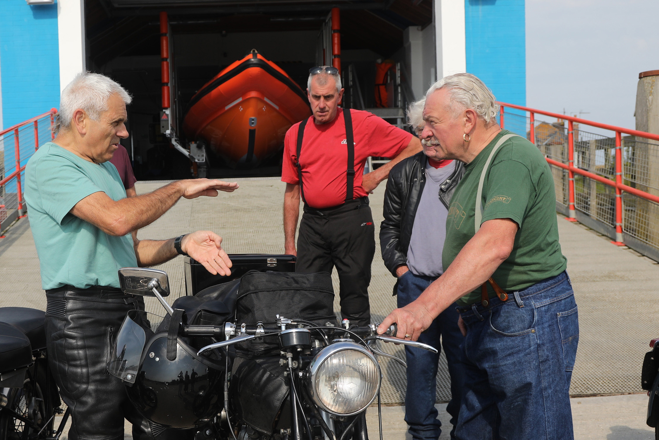 John Newson and his motorbike in front of the boathouse getting last-minute advice from friends