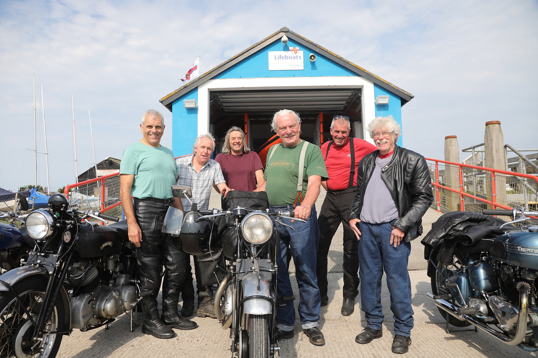 John Newson and biking friends pose in front of the boathouse