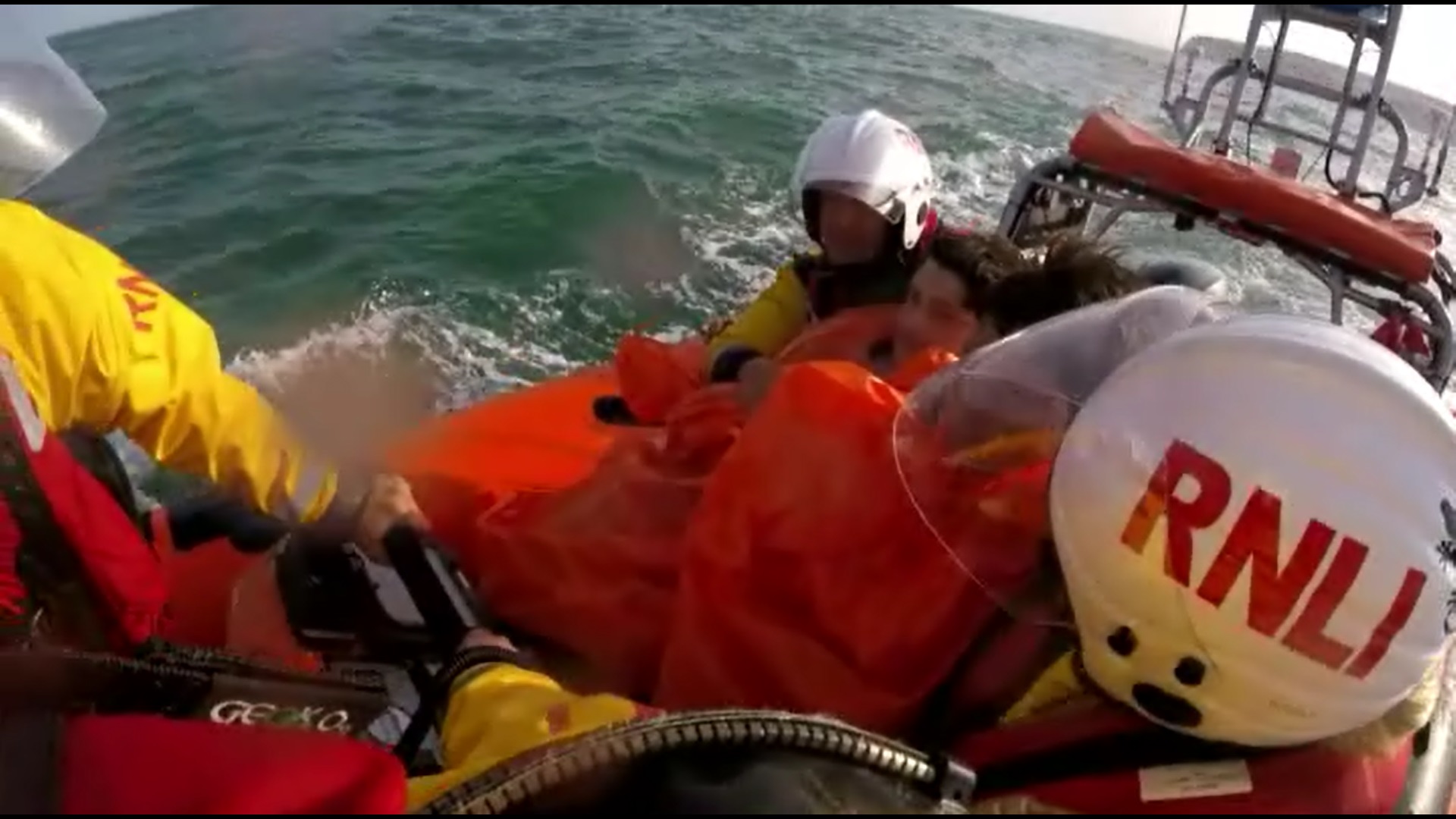 The two boys are taken aboard the lifeboat.