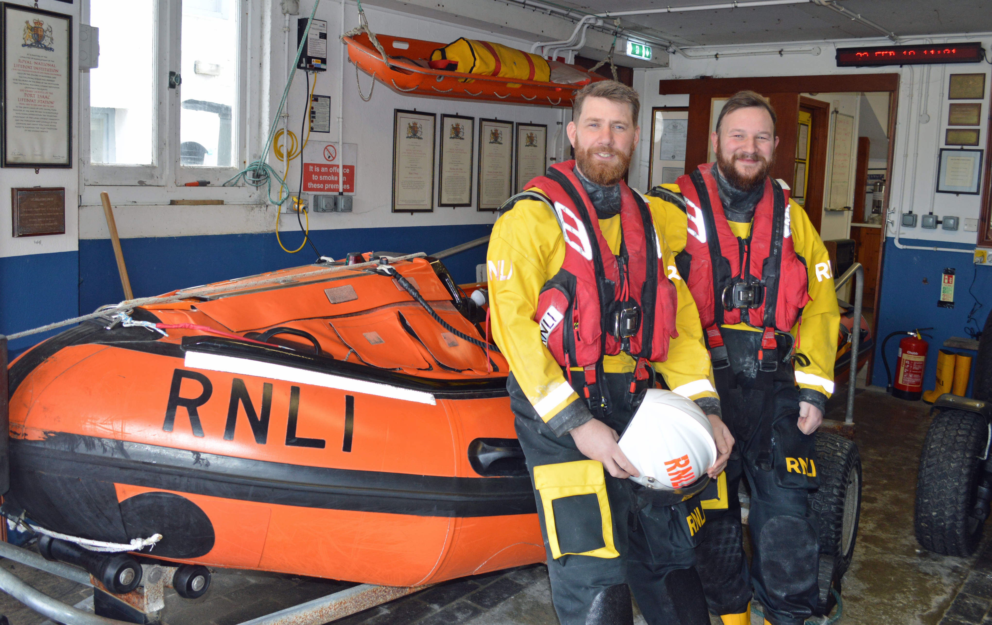 Tom and George in the boathouse, leaning against the inshore lifeboat