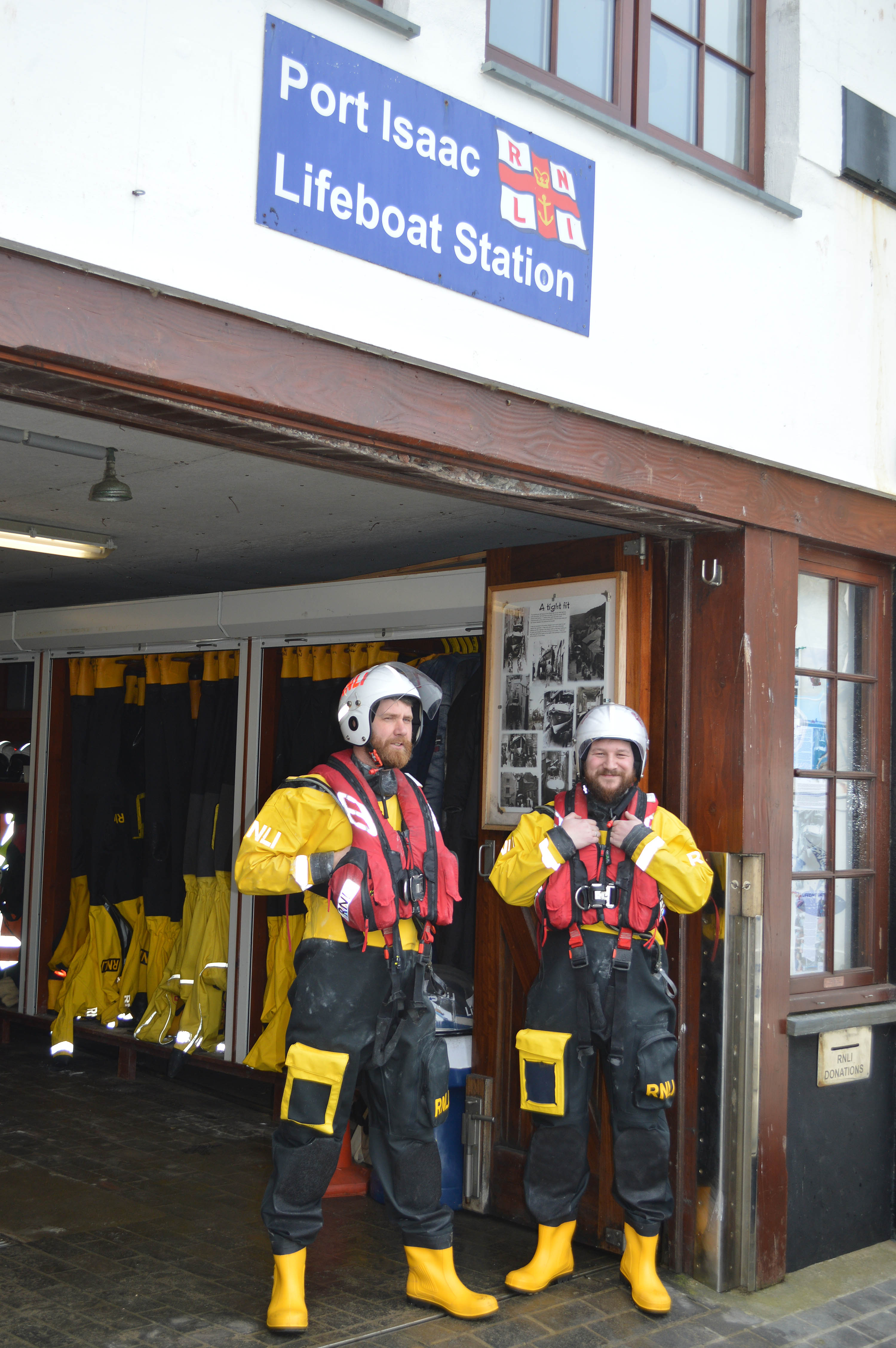 Tom and George in full crew kit stood with the station in the background