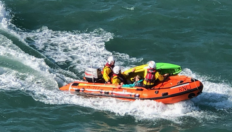 Inshore lifeboat and crew with kayaker making way to beach