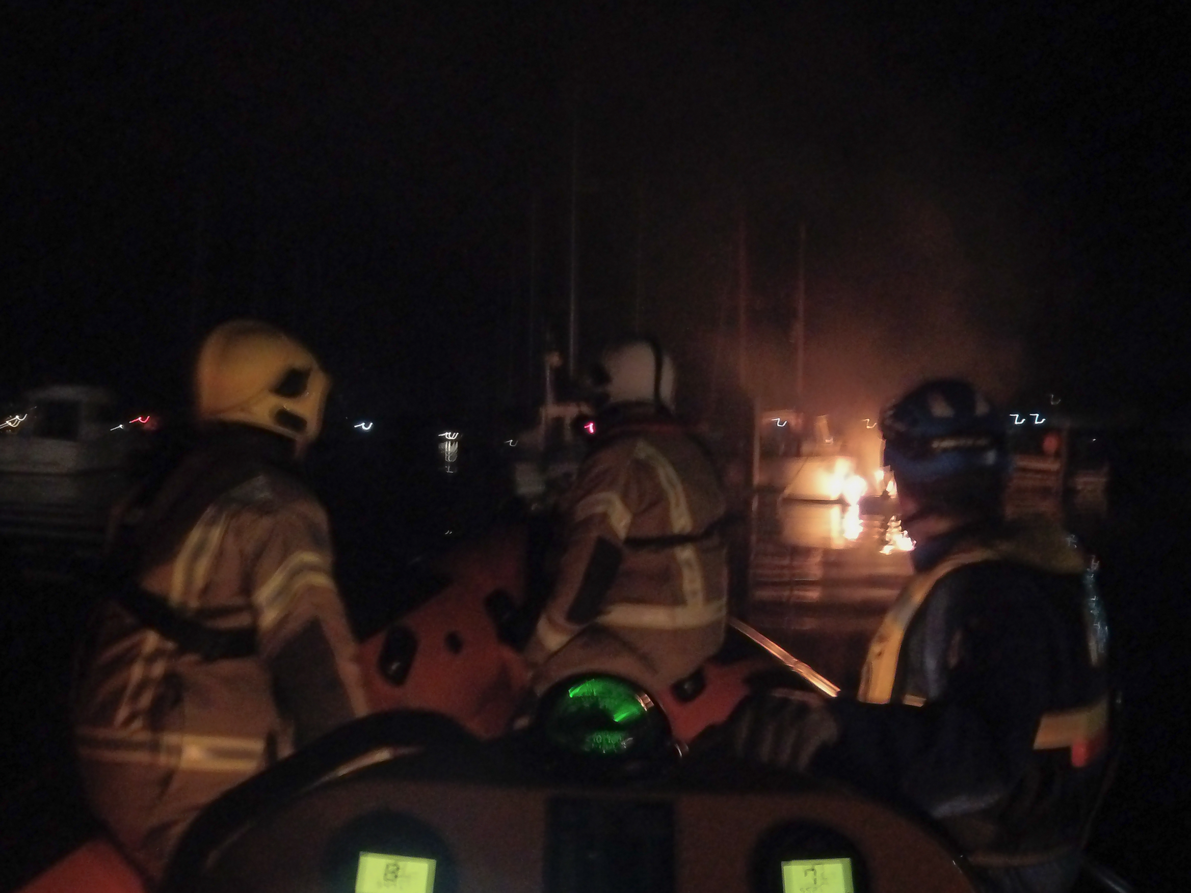 Night photo showing the Cowes crew at the scene of the boat fire.
