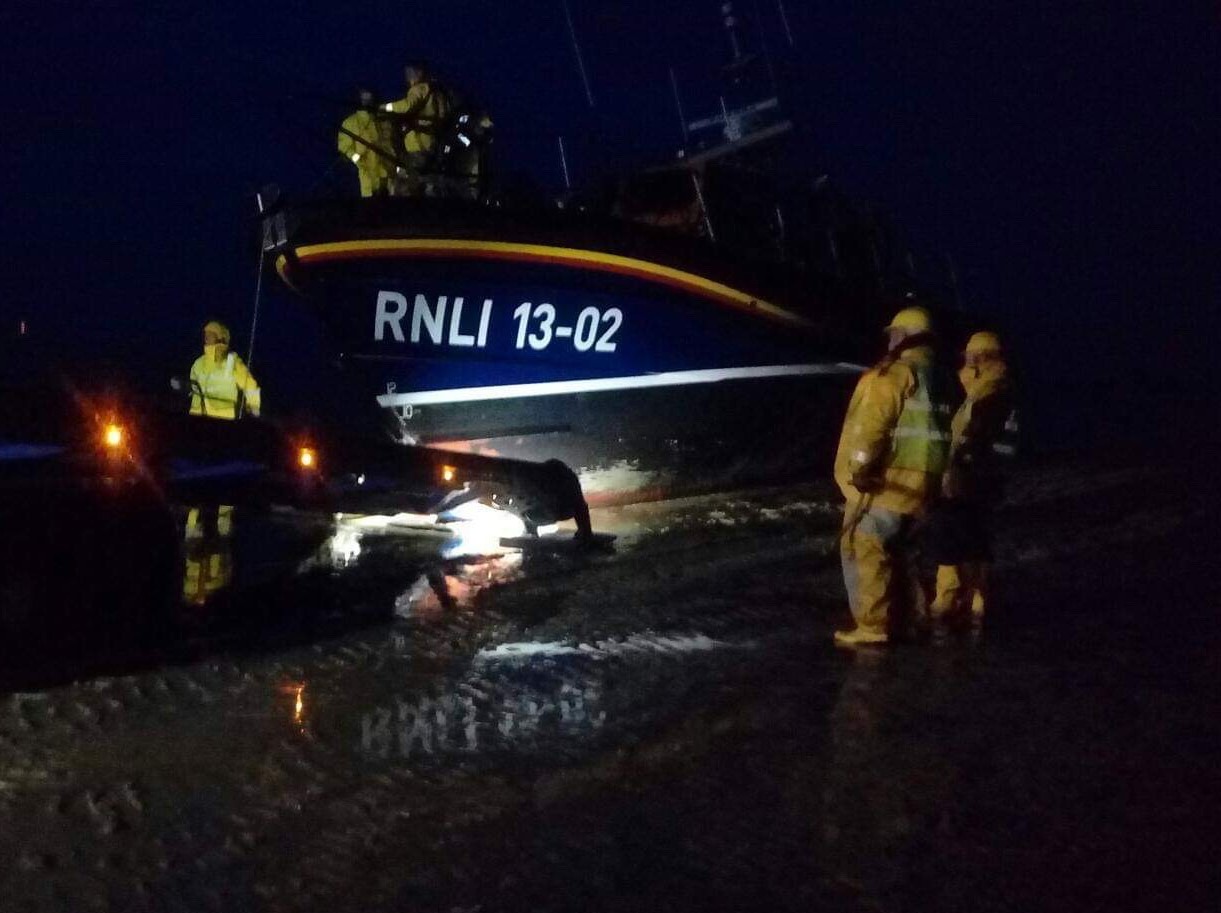 Photo in the dark showing the Shannon lifeboat on the beach and being recovered by the crew.