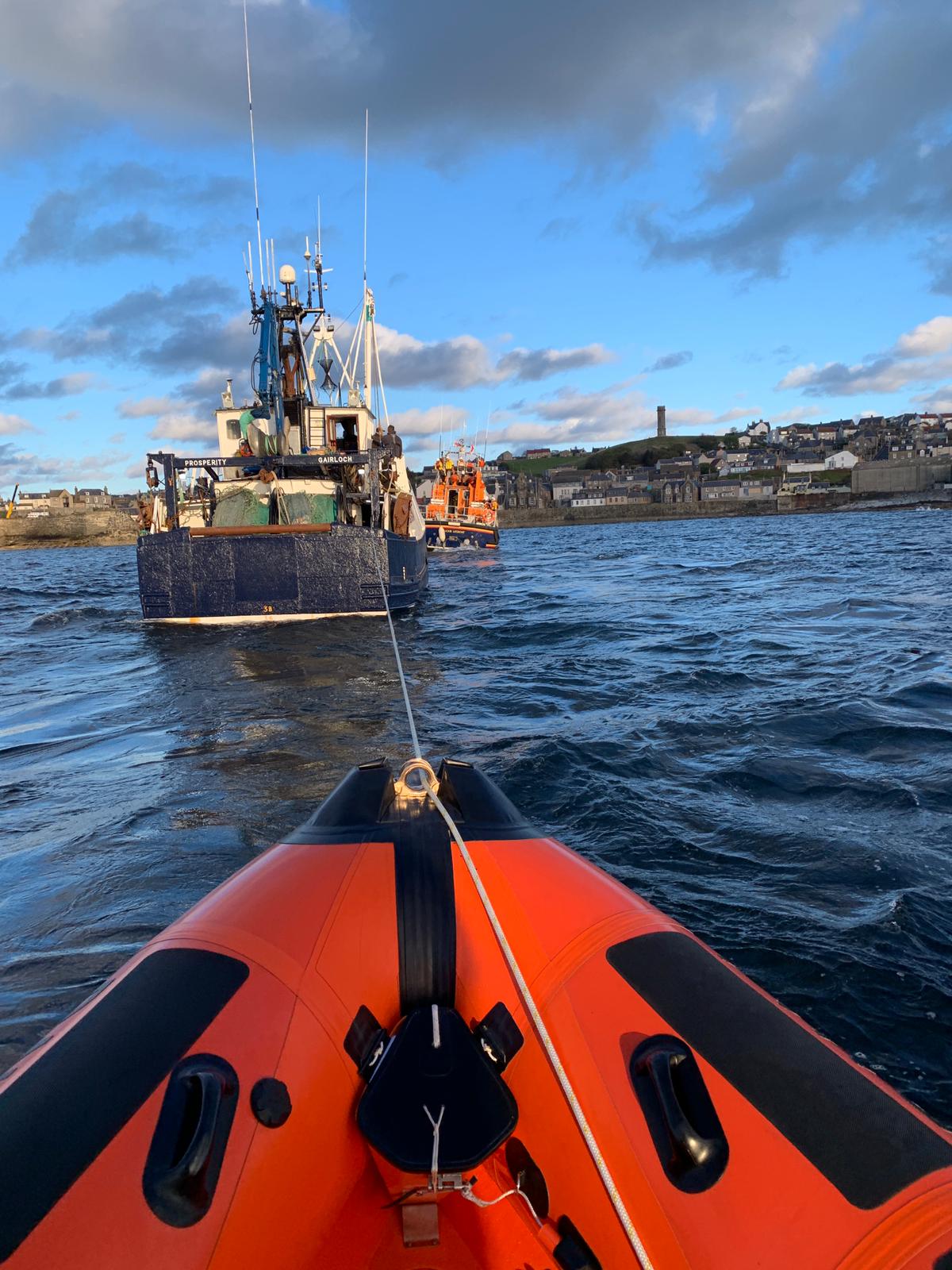 The Prosperity over the bow of Macduff lifeboat with Buckie lifeboat in view