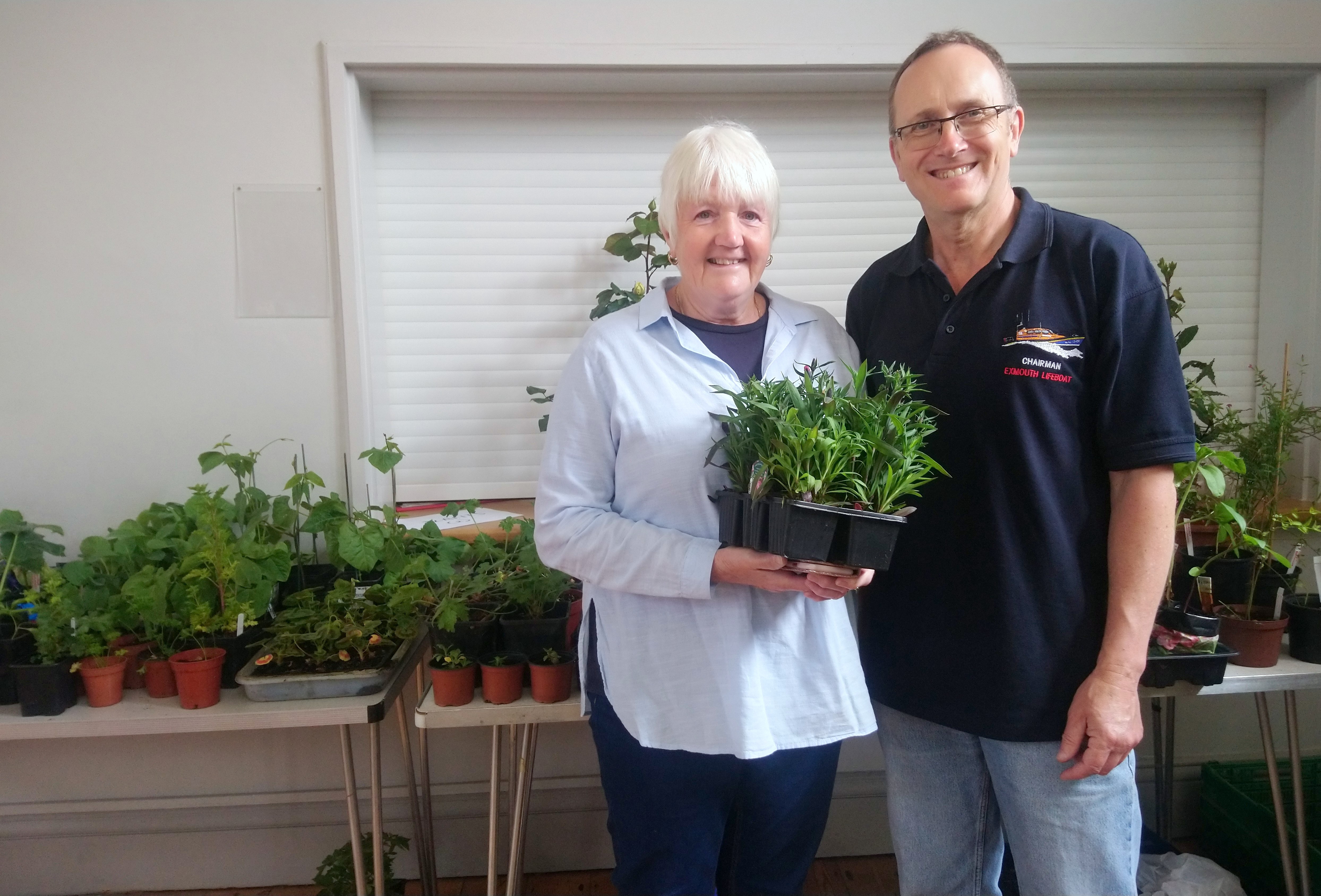 Mayor of Budleigh Salterton, Caz Sismore-Hunt buys a plant from Exmouth Lifeboat Management Group Chair, Simon Davidson.
