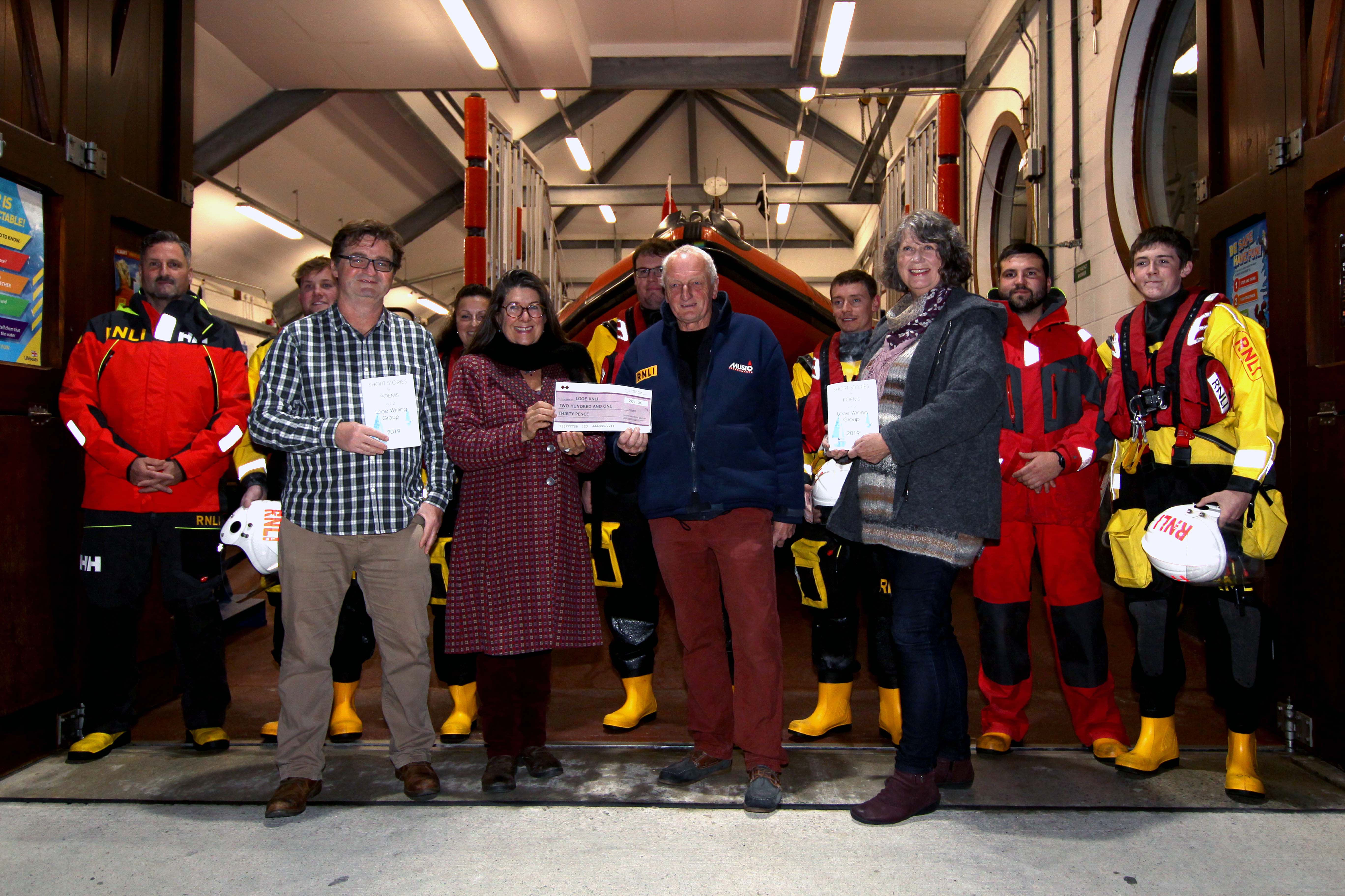 Cheque presentation by Jane Malcolm, Looe Writers Group to Dave Haines Looe RNLI with Jim Rickard, Viv Bennett and Looe RNLI volunteers crew
