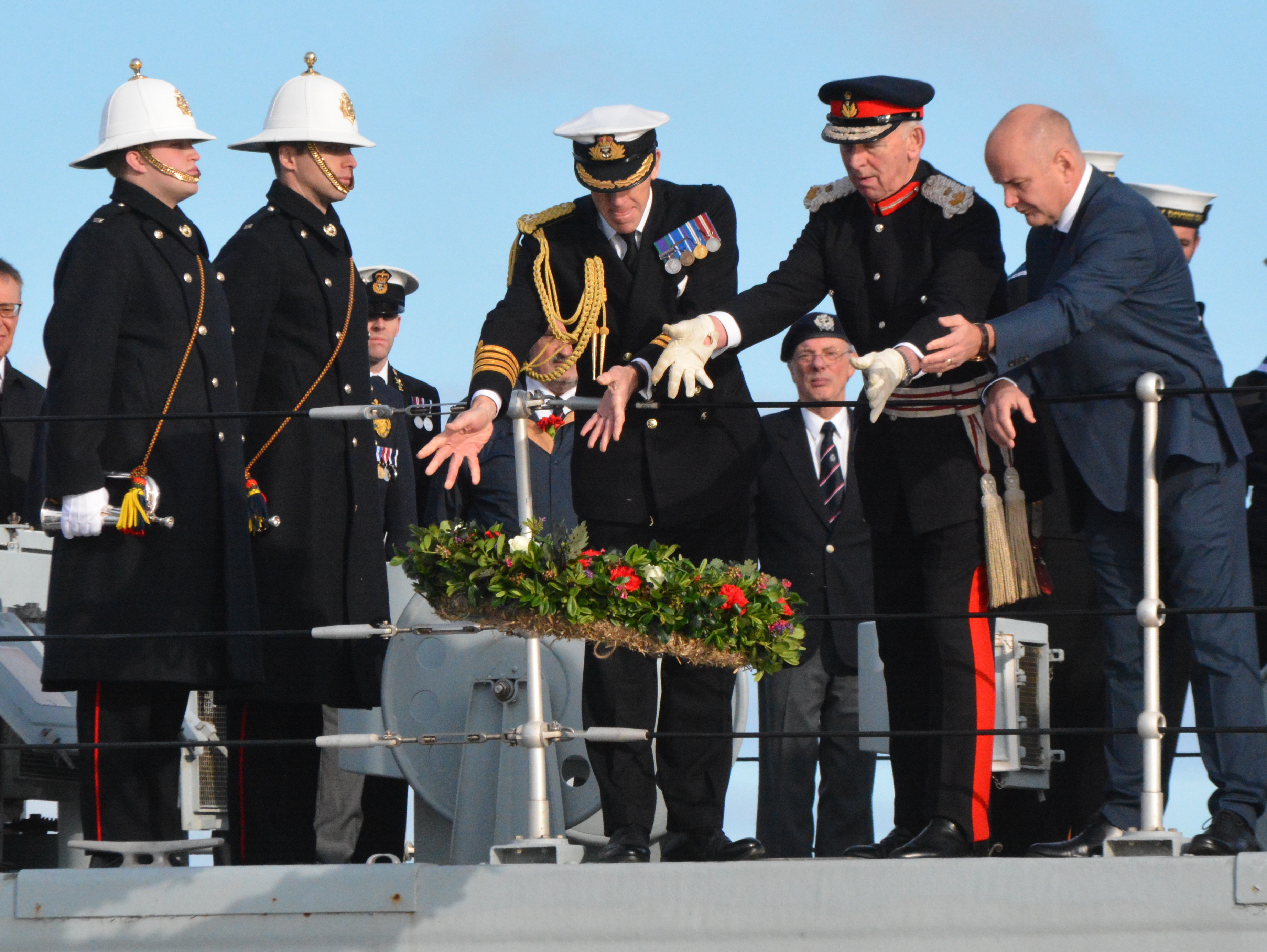 Poppy wreath is laid on the water from HMS Bangor