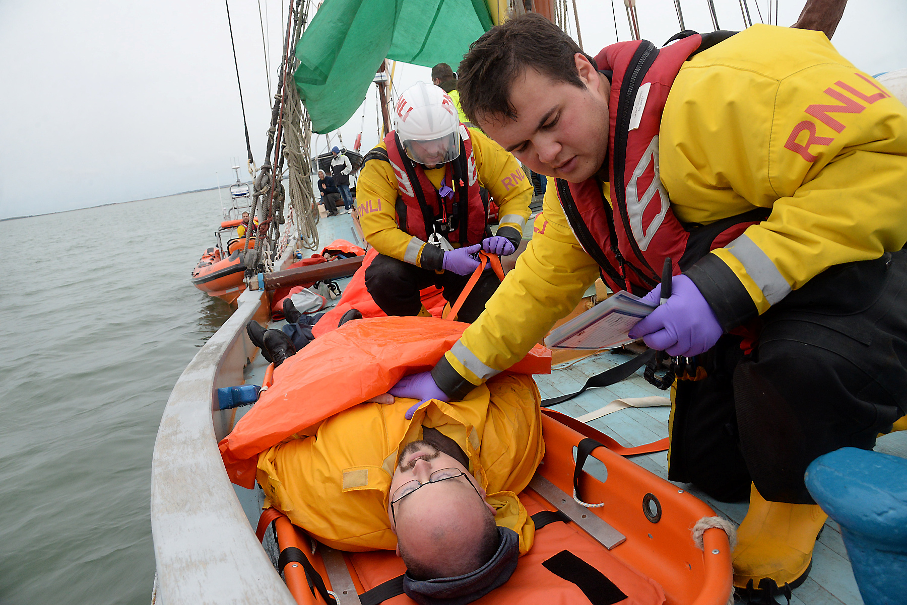 Alex Quan makes a check on casualty Scott Goudie during the 2019 Whitstable Lifeboat 'Dan Davies' first aid and seamanship exercise onboard the sailing barge Greta on Saturday. Picture:RNLI Whitstable.