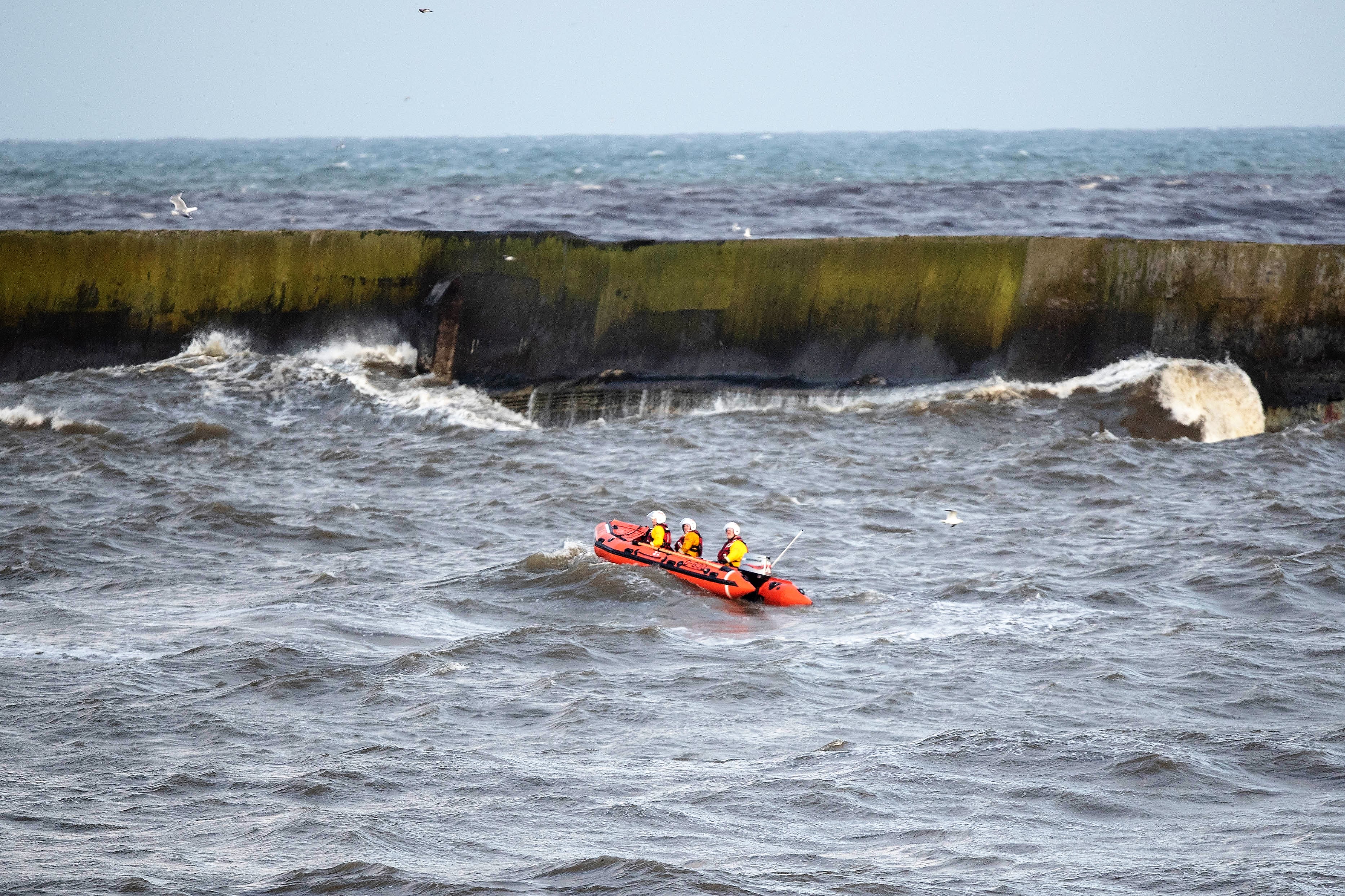 Aberdeen's inshore lifeboat 'Bouy Woody 85N' gets a rough ride in the surf around the harbour's north breakwater during today's search