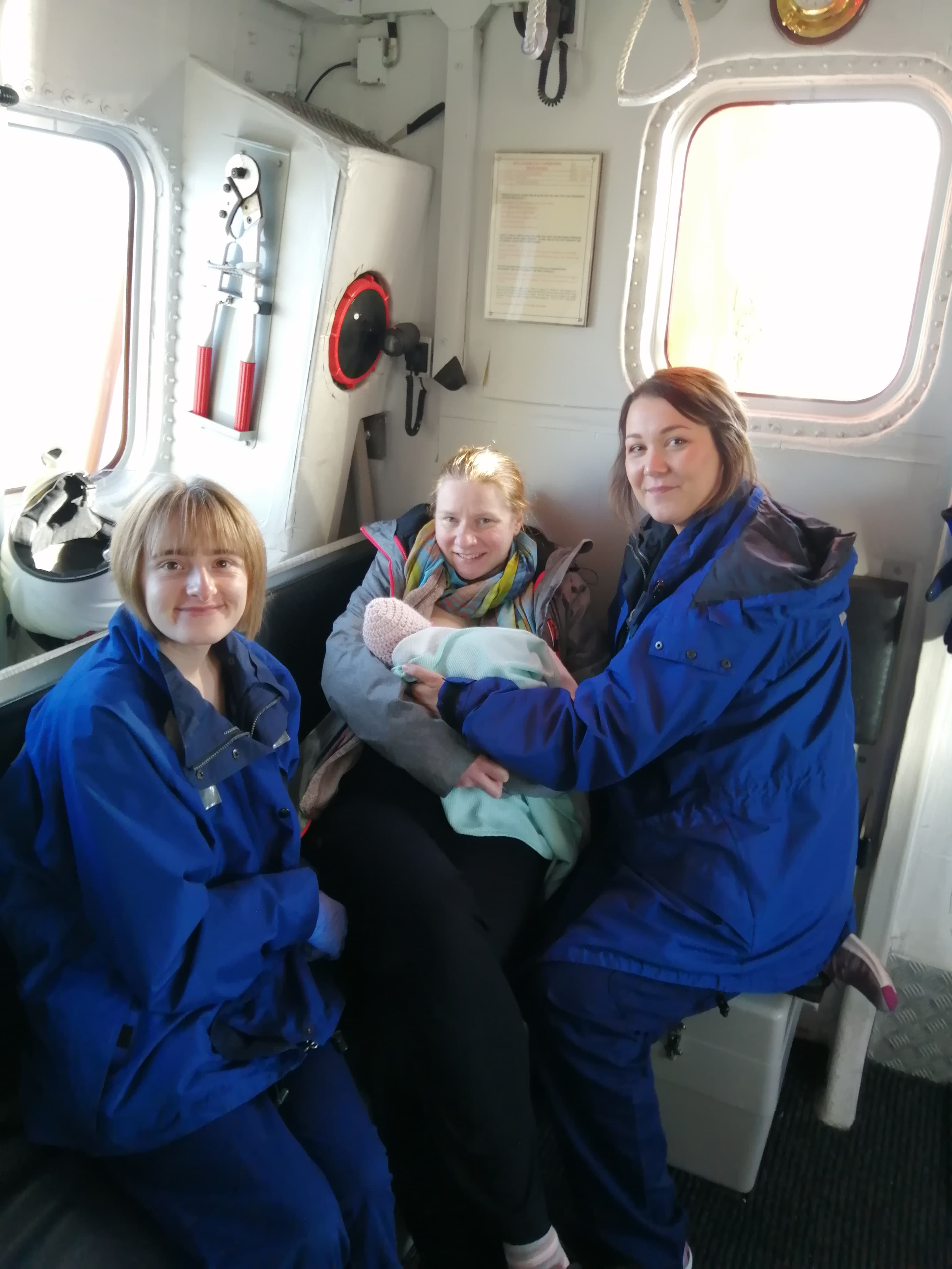 Mum and baby with two midwives inside lifeboat cabin