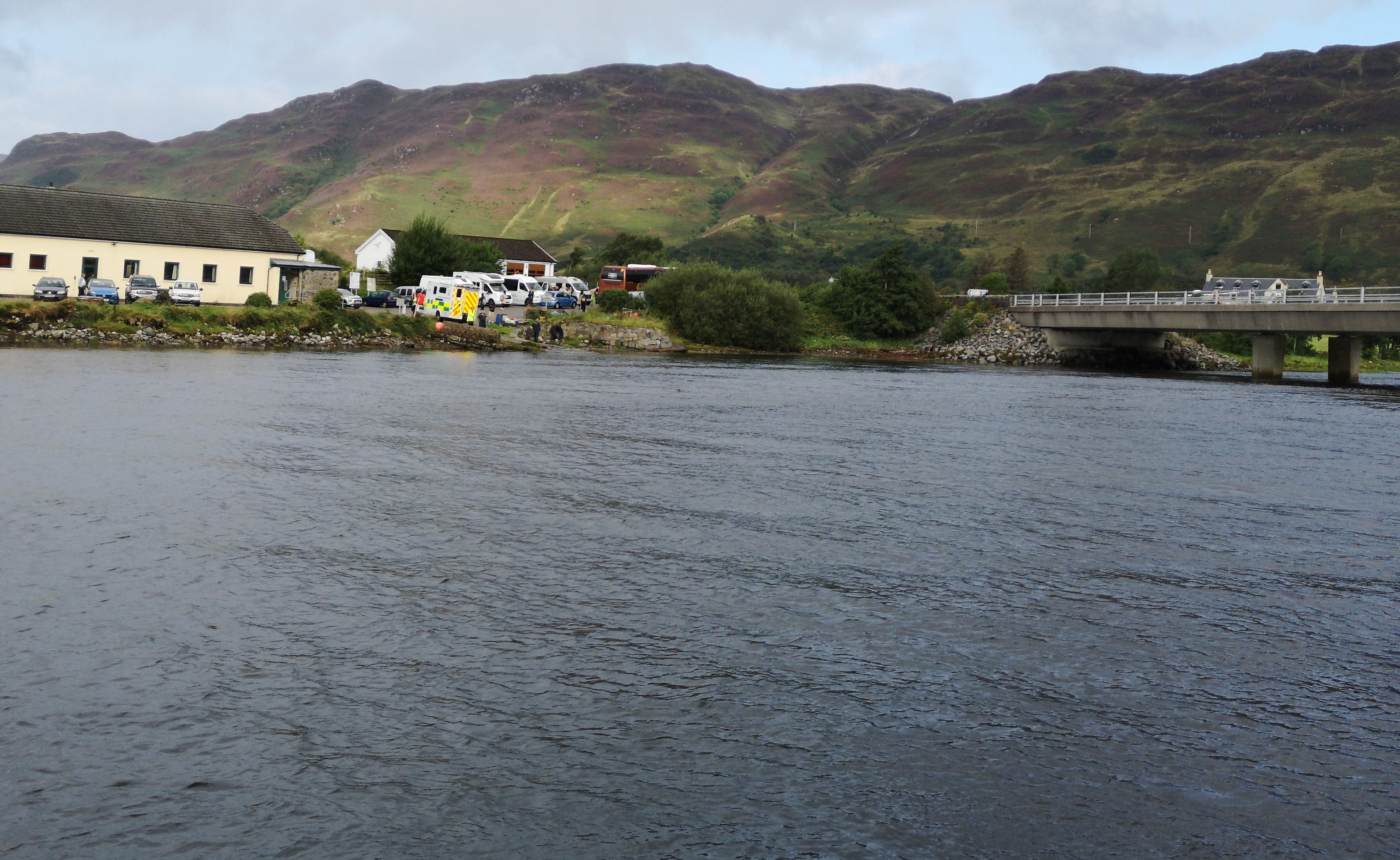 Ambulance waiting at the Dornie Hall slipway with the top of the helicopter just visible over the bridge