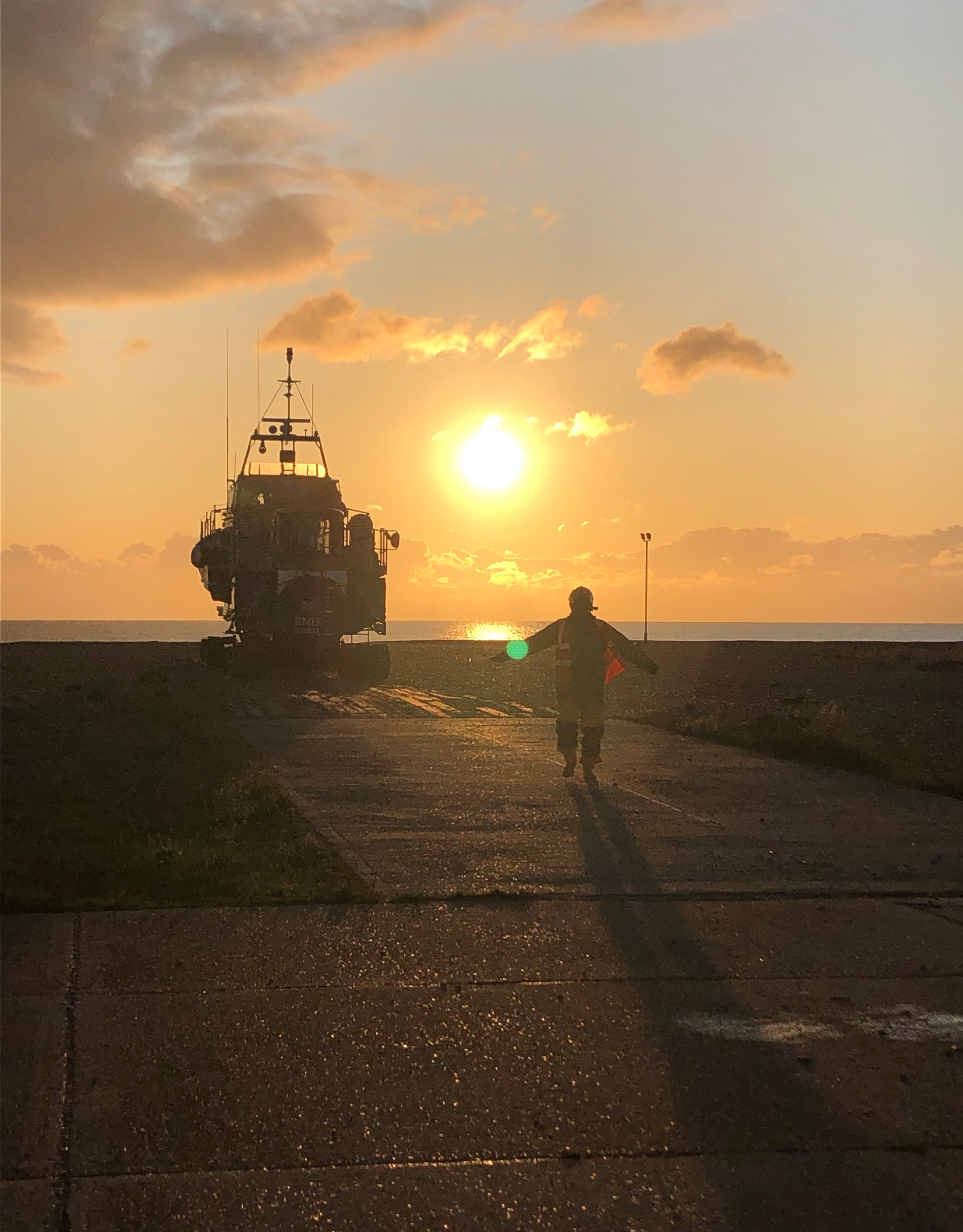 lifeboat is being directed by the head launcher with the sun rising in the background