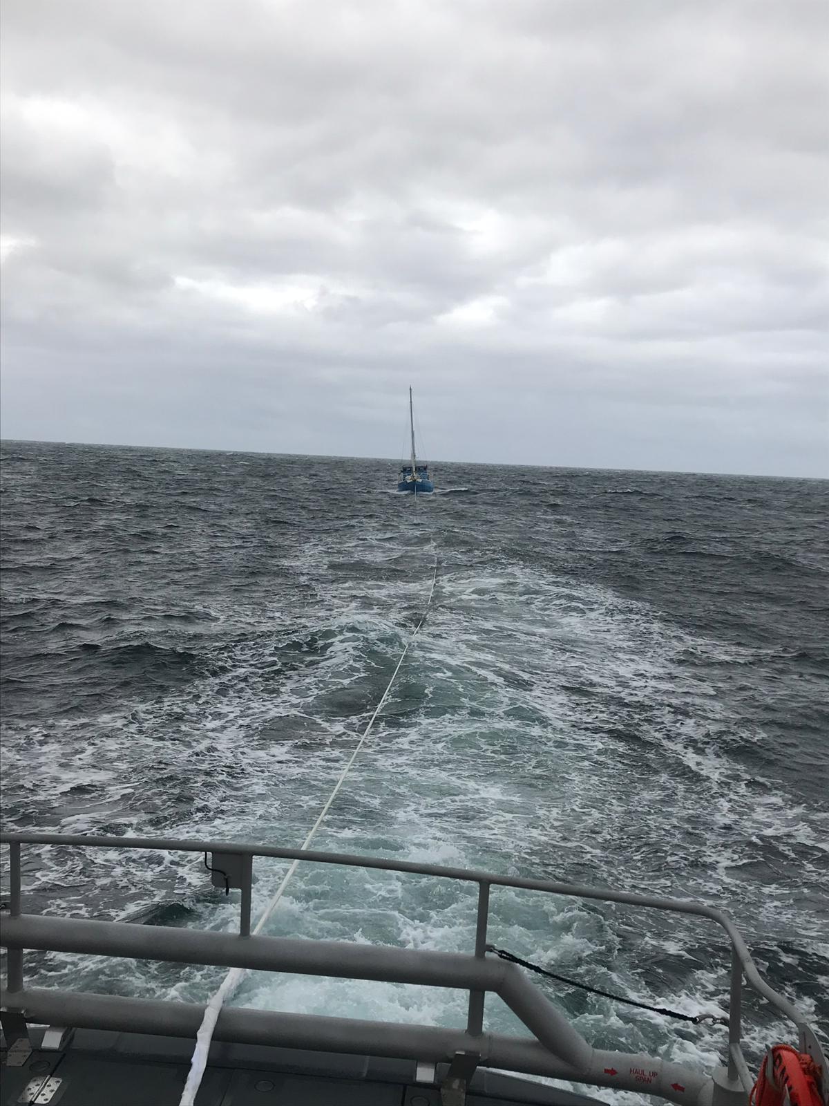 Motor cruiser being towed by lifeboat
