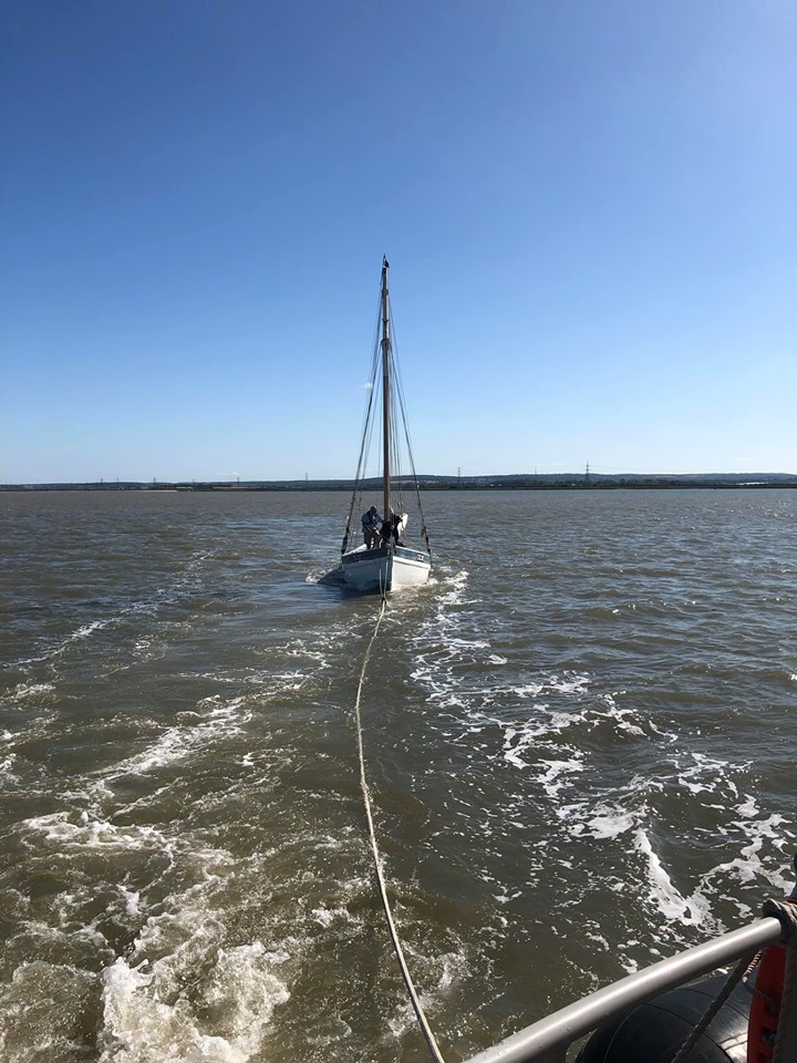 The ancient fishing vessel under tow.