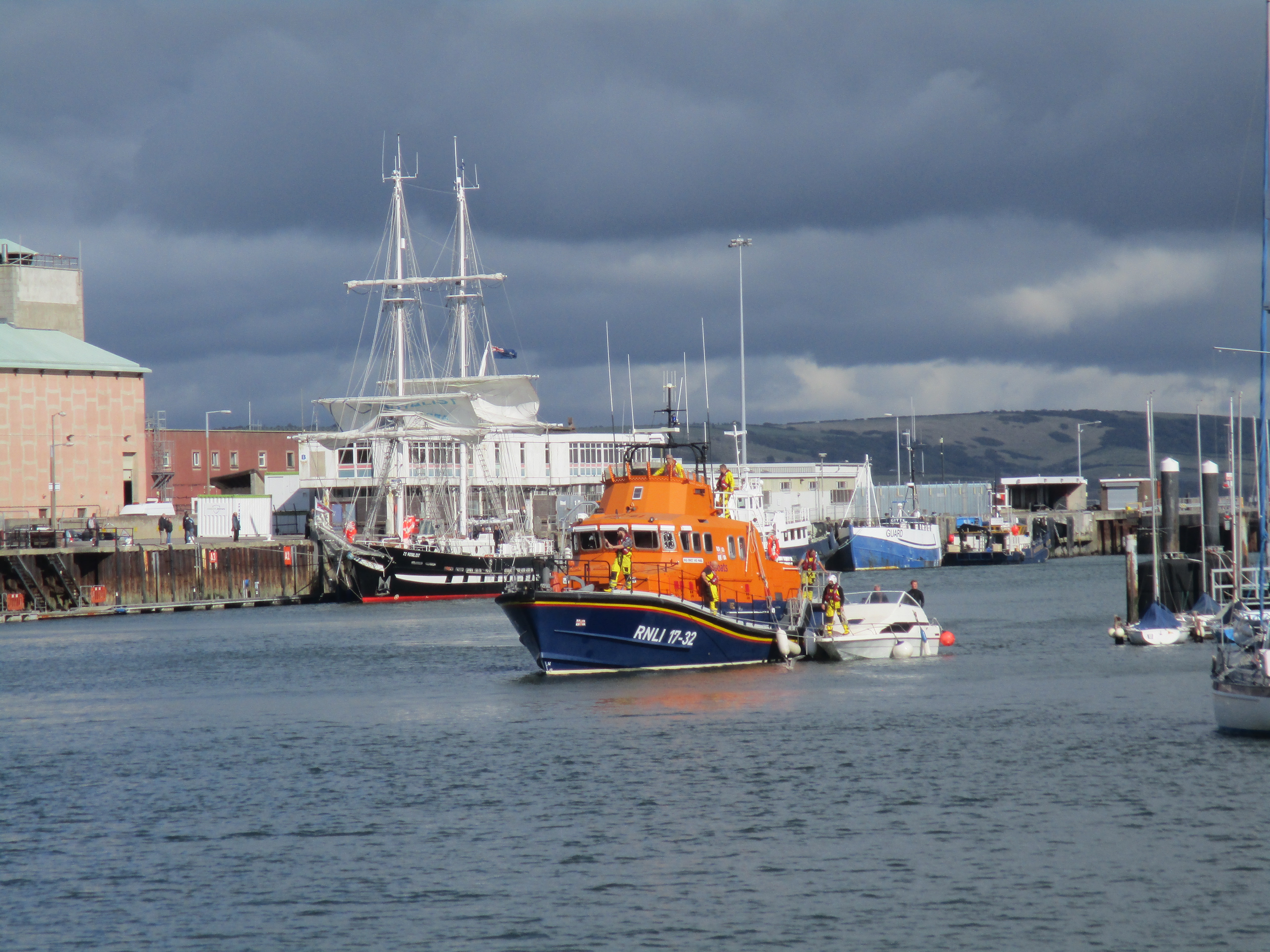The all weather lifeboat bringing in cabin cruiser into the harbour