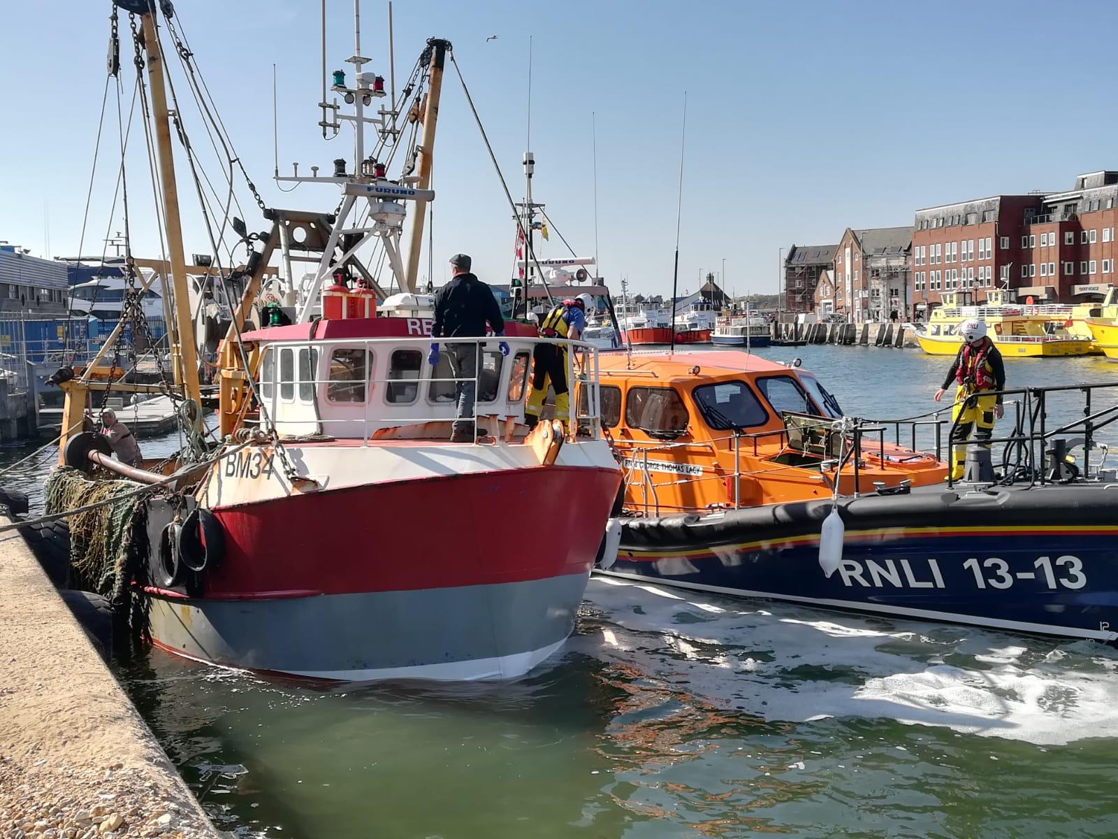Swanage lifeboat putting the casualty fishing alongside Poole Quay