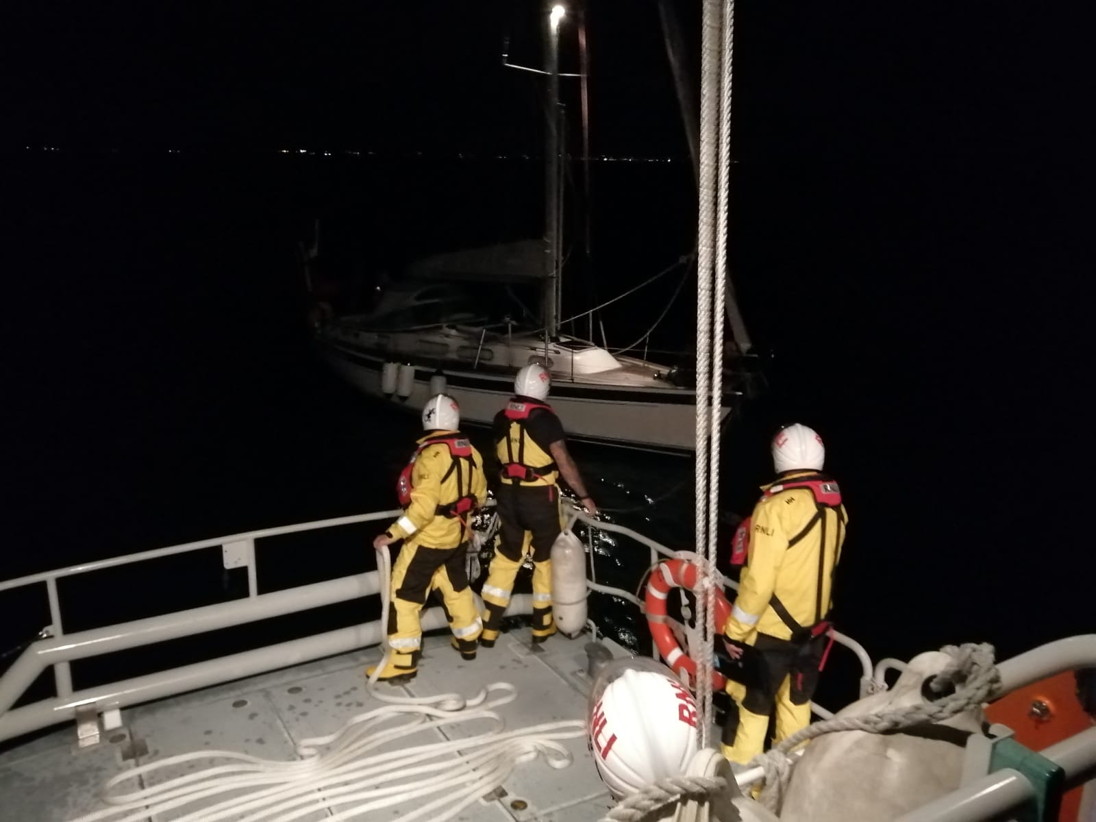 Volunteer crew preparing to pass towline to disabled yacht