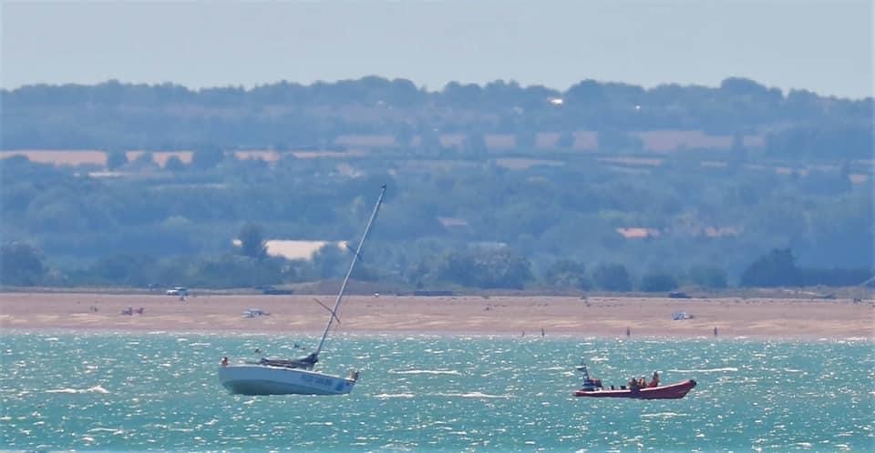 The stricken yacht being pulled by the inshore lifeboat 'Claire and David Delves'.