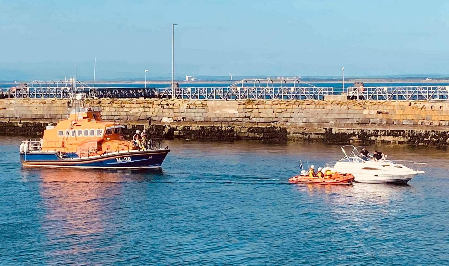 Troon RNLI all-weather and inshore lifeboat with the casualty vessel under tow