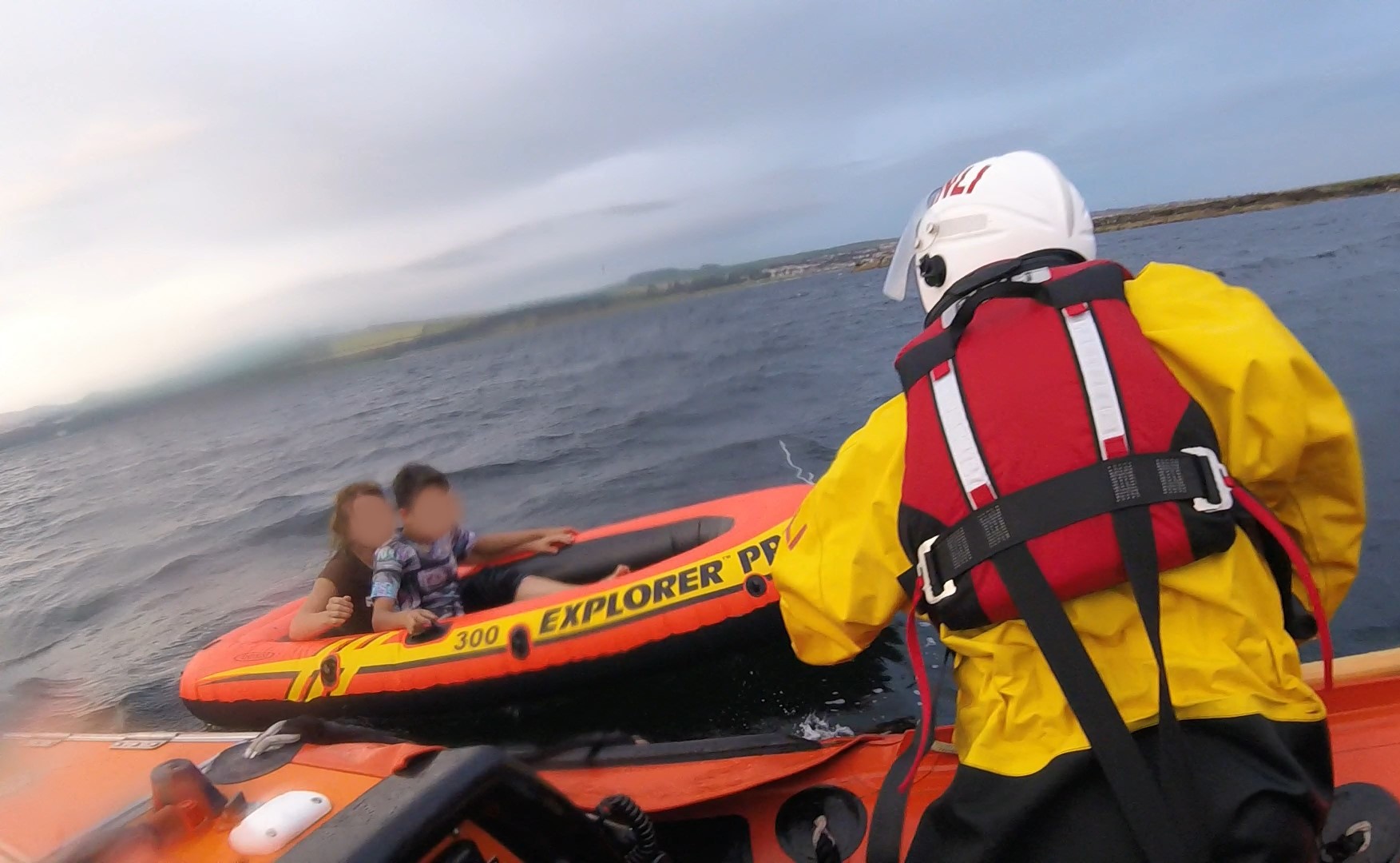 Troon RNLI inshore lifeboat crew approach the inflatable dinghy