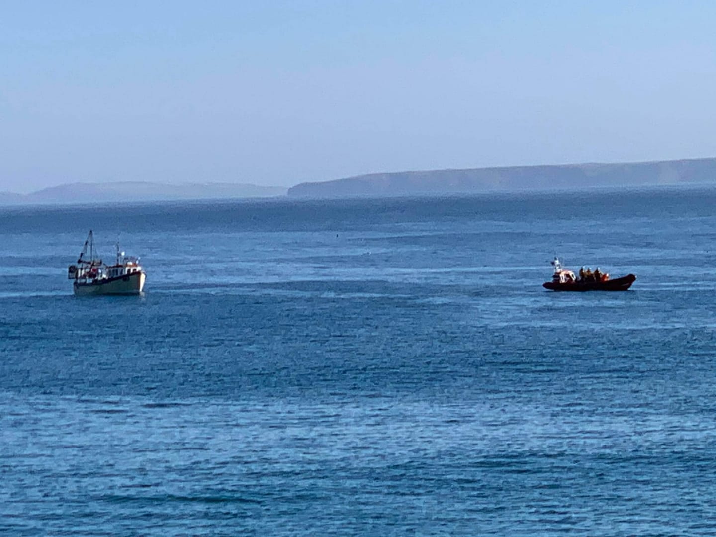 Newquay lifeboat towing fishing boat to safety across Newquay Bay