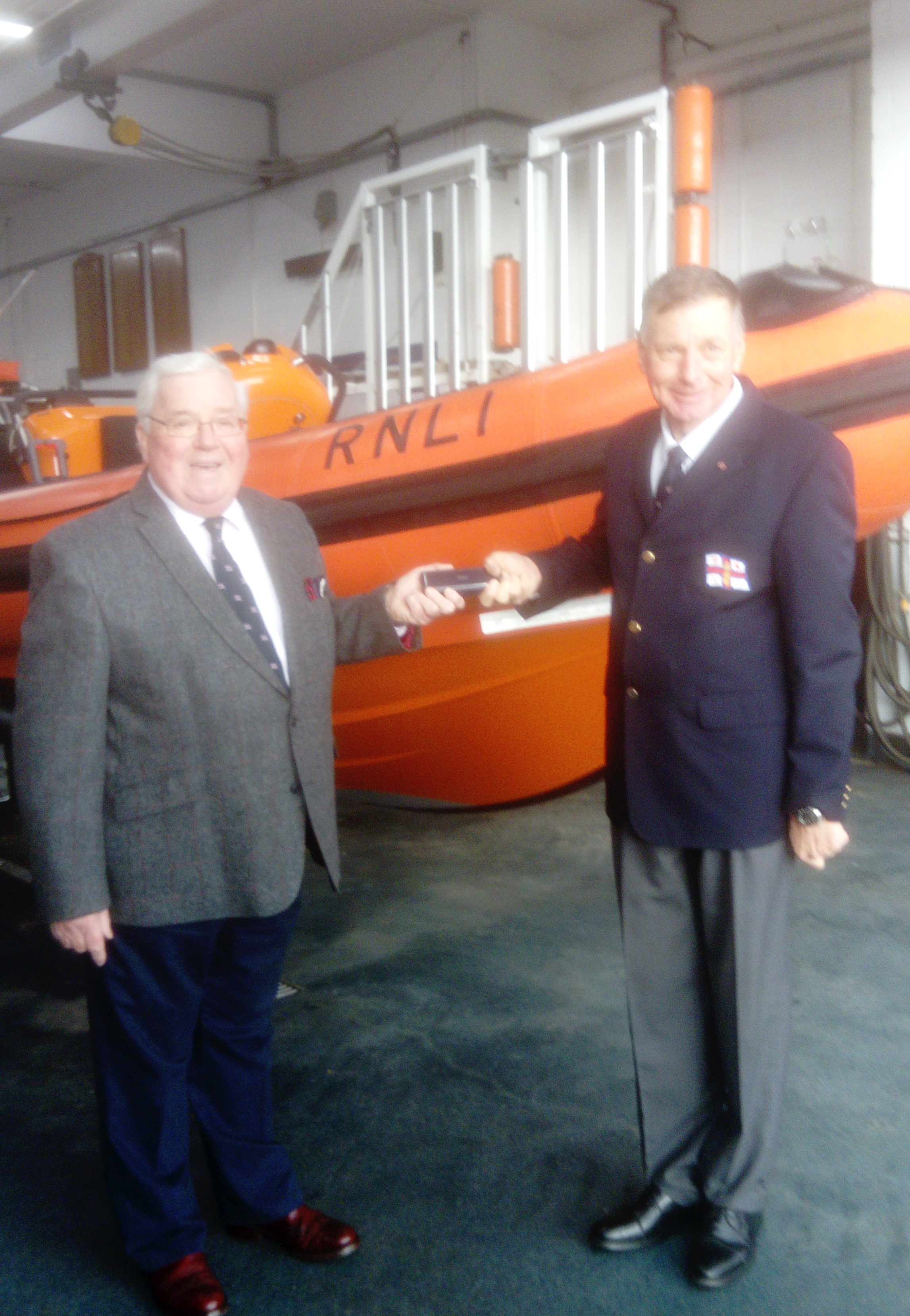 Phil Missen MBE, Porthcawl Lifeboat Operations Manager is presented the RNLI's Long Service Medal from Station President, Peter Scott.