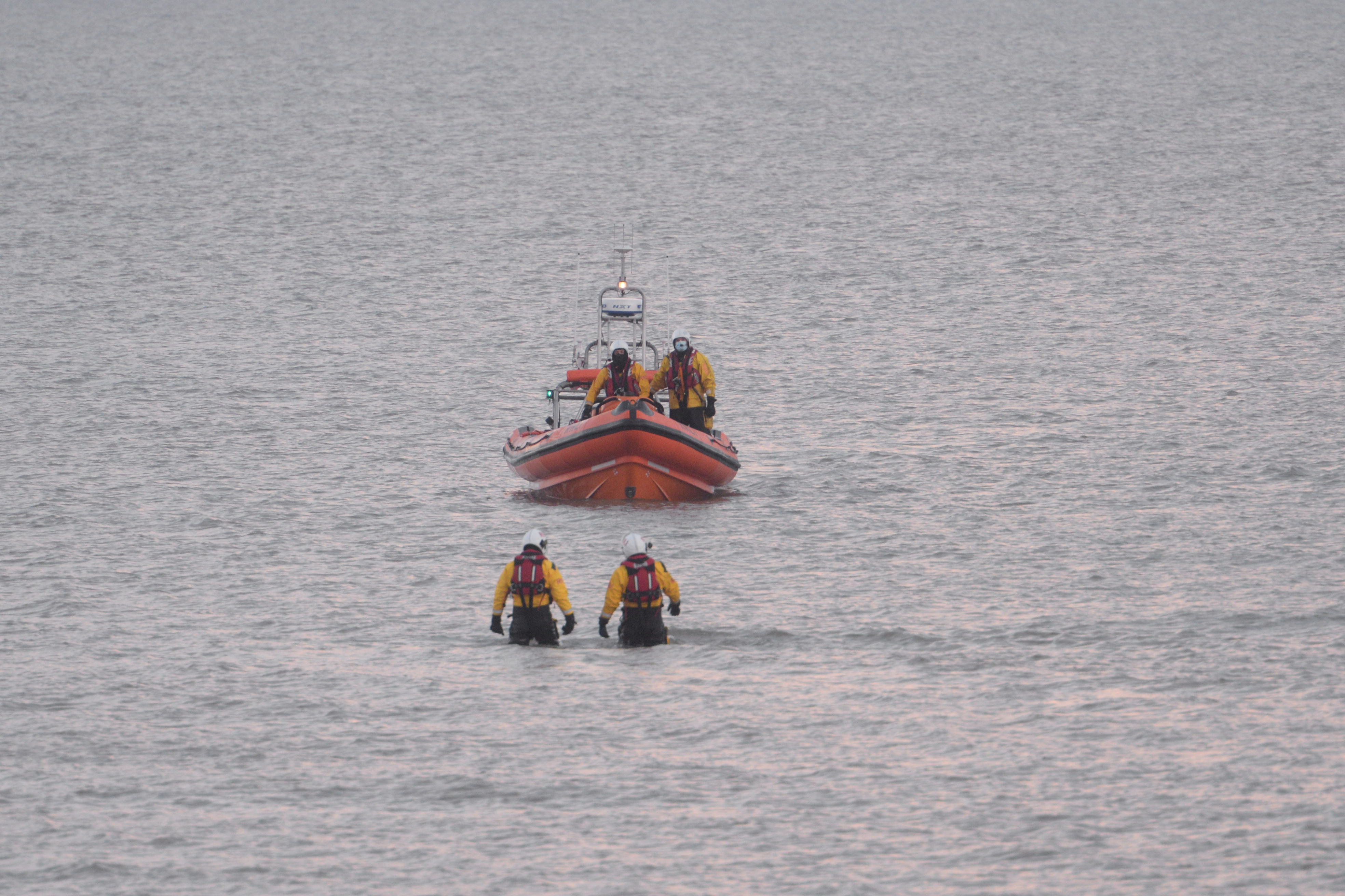 Two members of the Whitstable lifeboat crew make their way back to the waiting lifeboat after 'walking'' the broken down angling dory and it's three occupants ashore on Saturday morning.