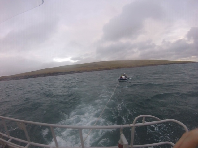 RIB being towed with island of Graemsay visible behind