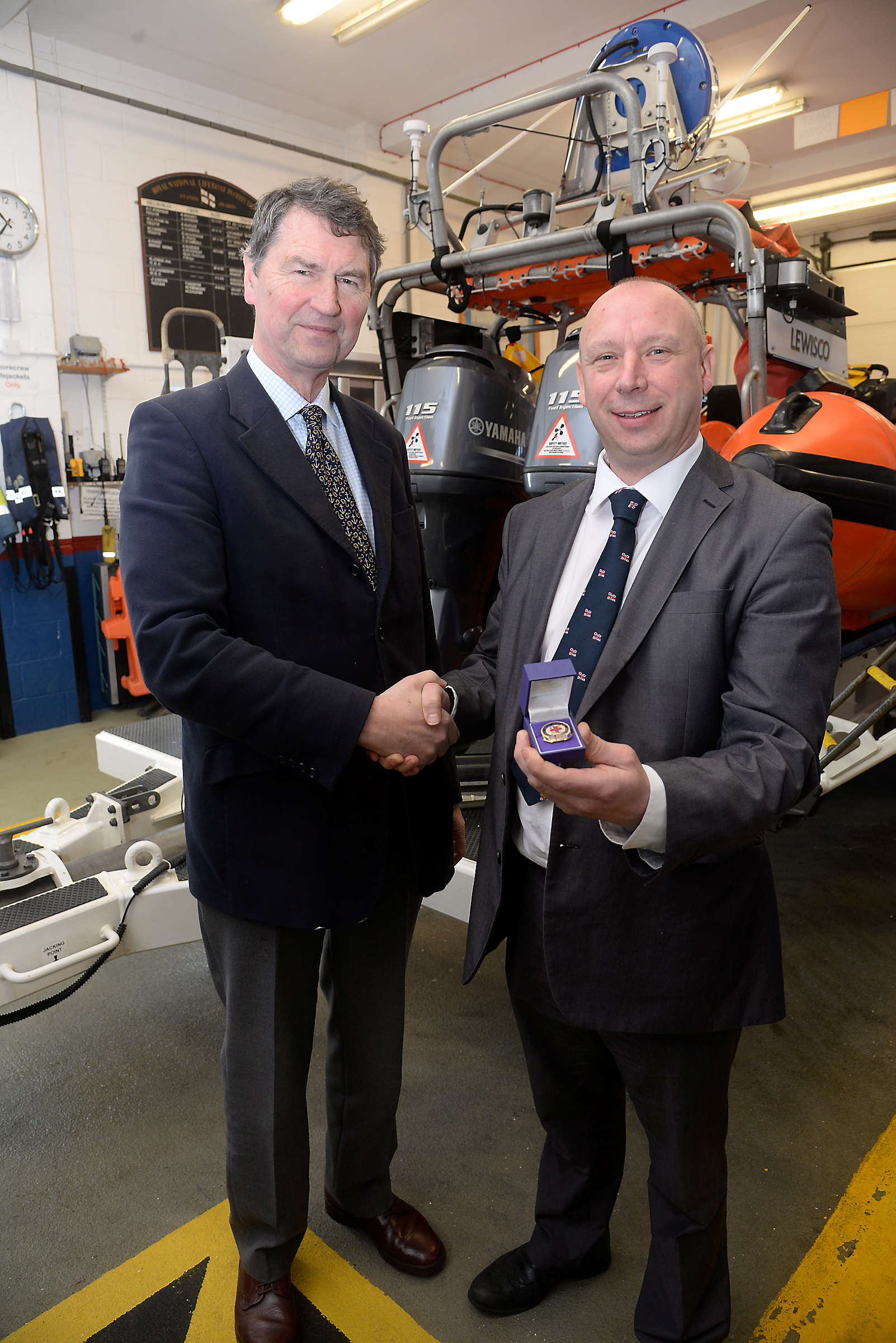 Vice-Admiral Sir Timothy Lawrence presents crewmember Stuart Enderby with his 20-year service badge at Whitstable Lifeboat Station on Tuesday. Picture:RNLI Whitstable.