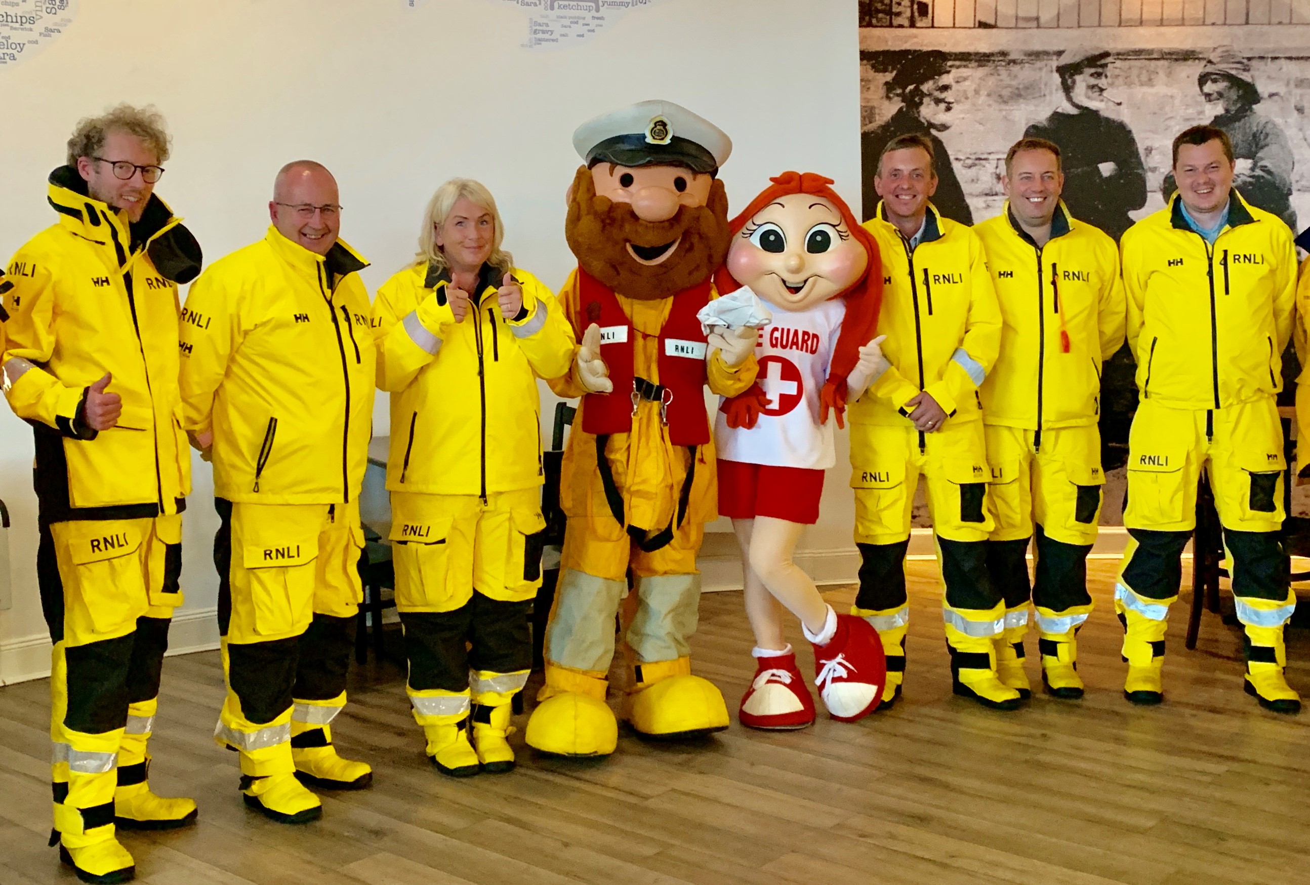 Crew members line up for a photo with the RNLI's Stormy Stan and lifeguard mascot