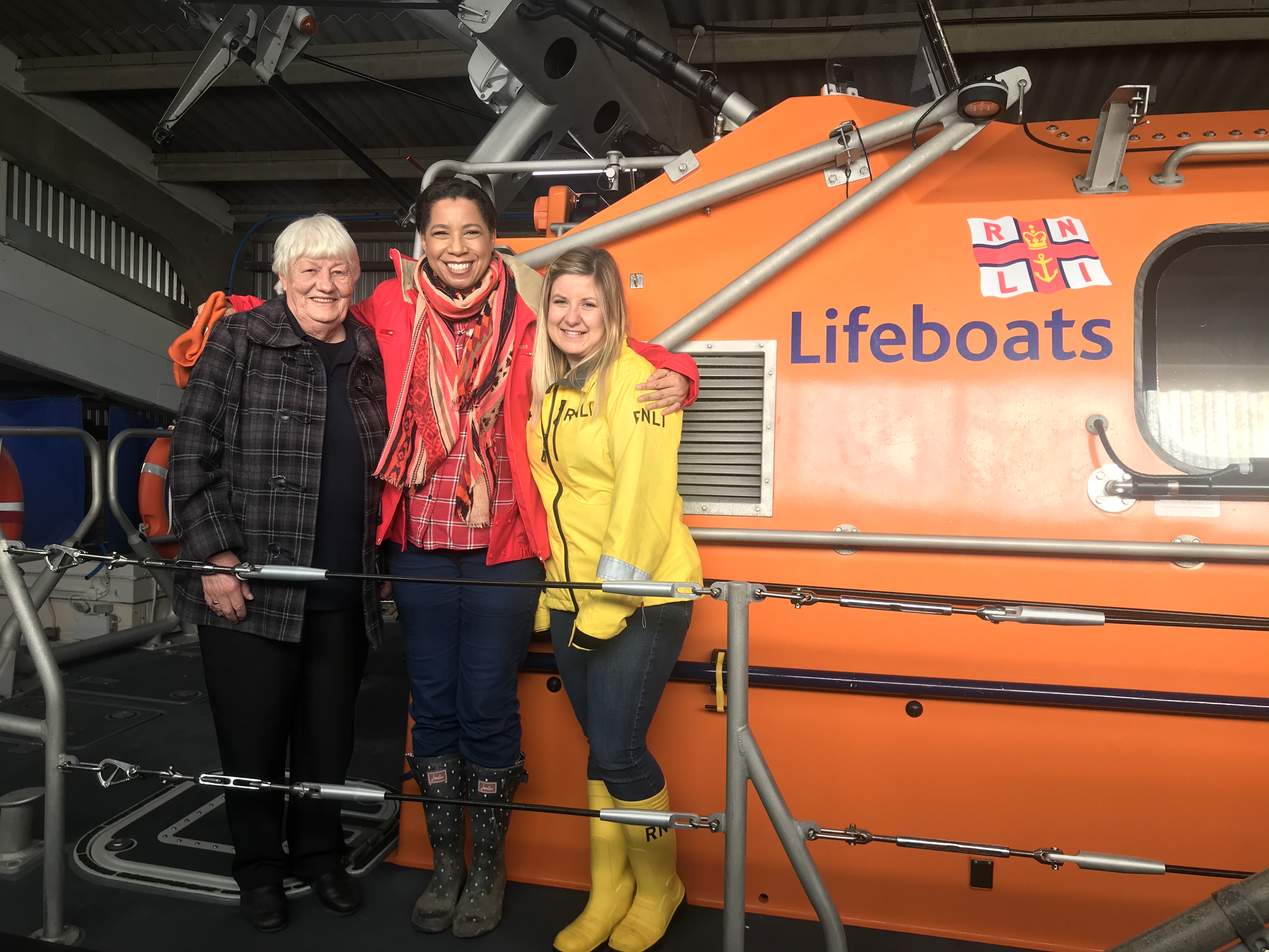 3 ladies stand on the deck of the lifeboat 