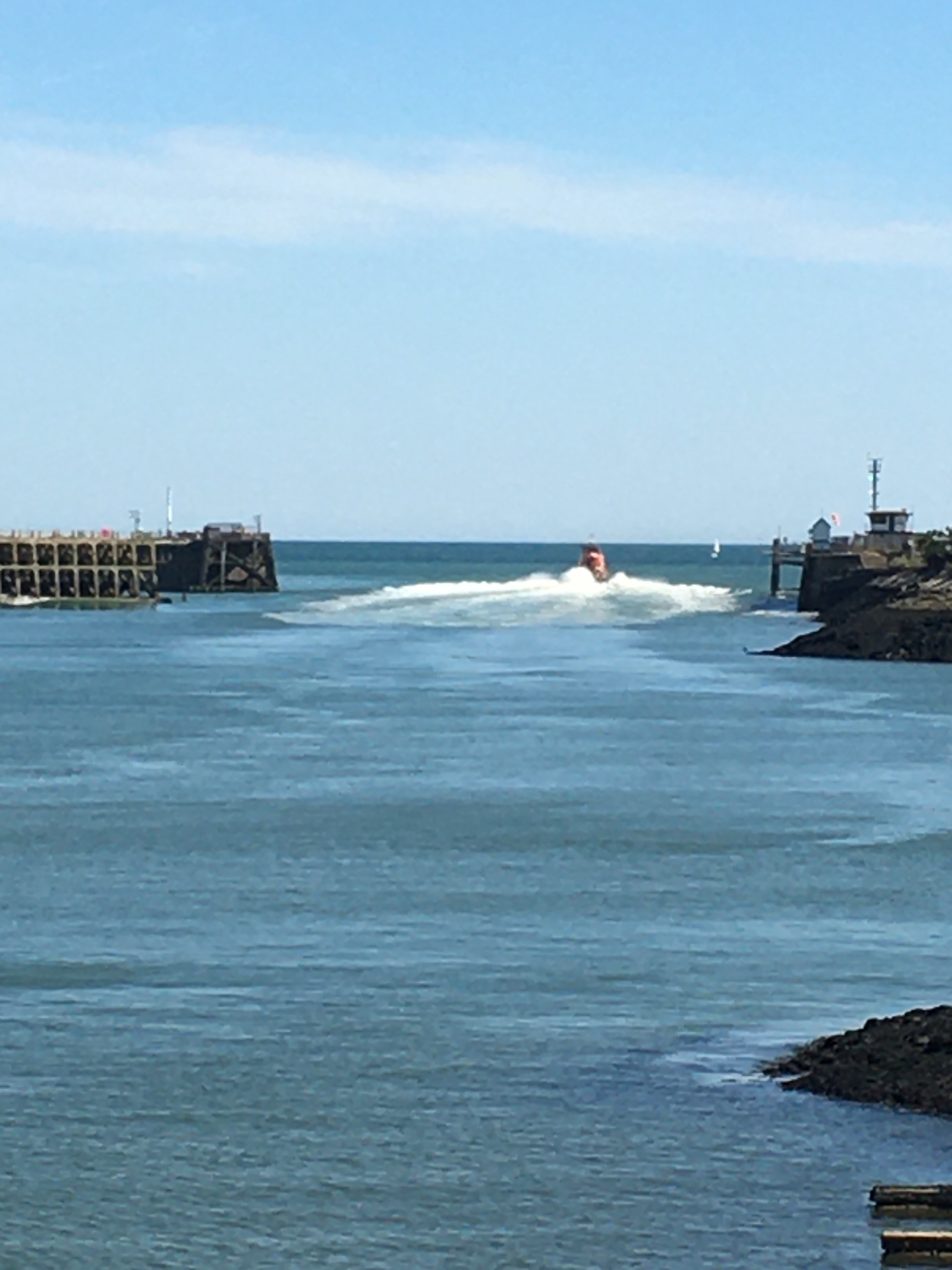 View of Severn Class Lifeboat 'David and Elizabeth Acland' and vessel wake making way out through Newhaven harbour.
