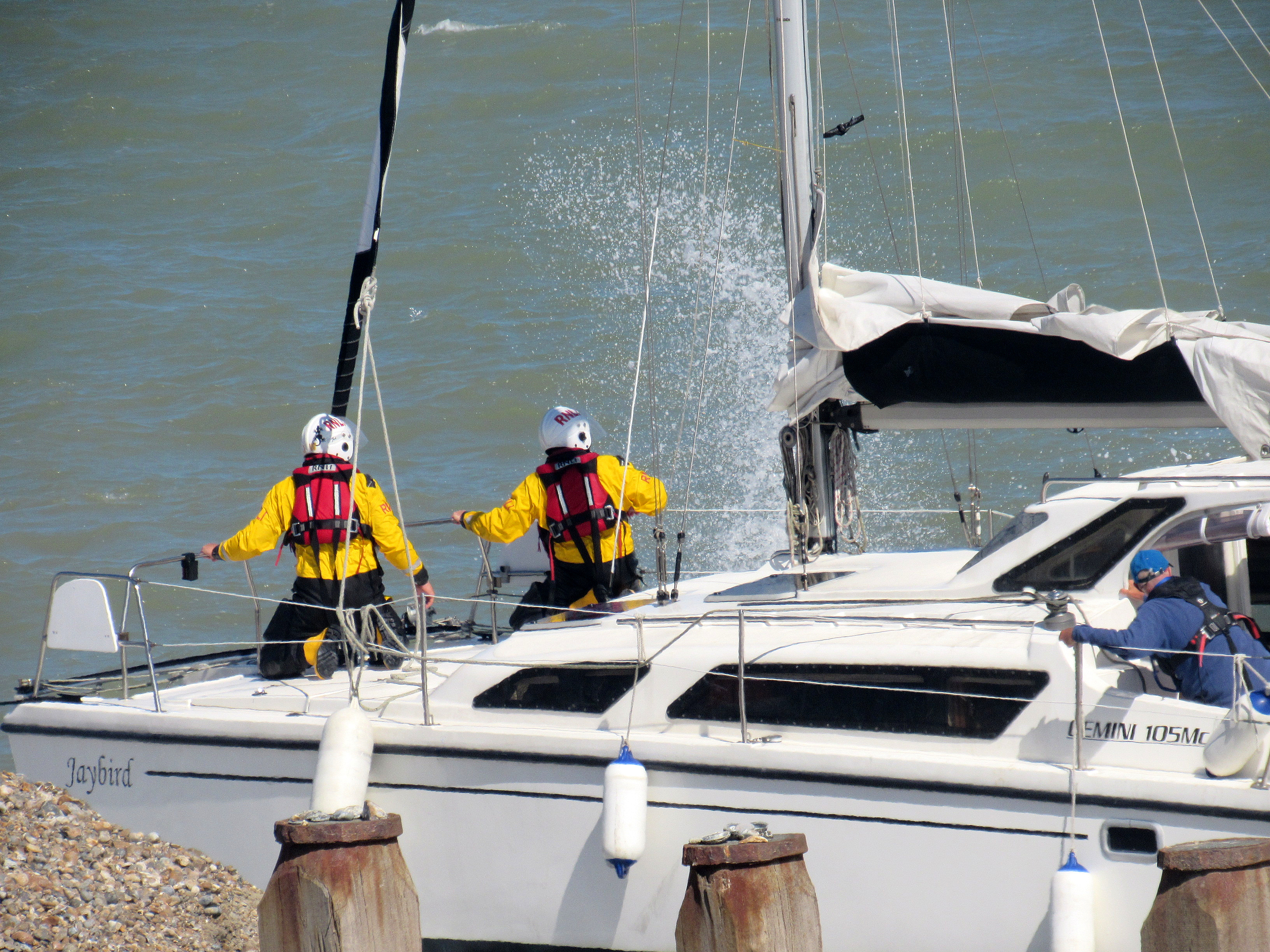 Lifeboat crew securing towline on stranded yacht