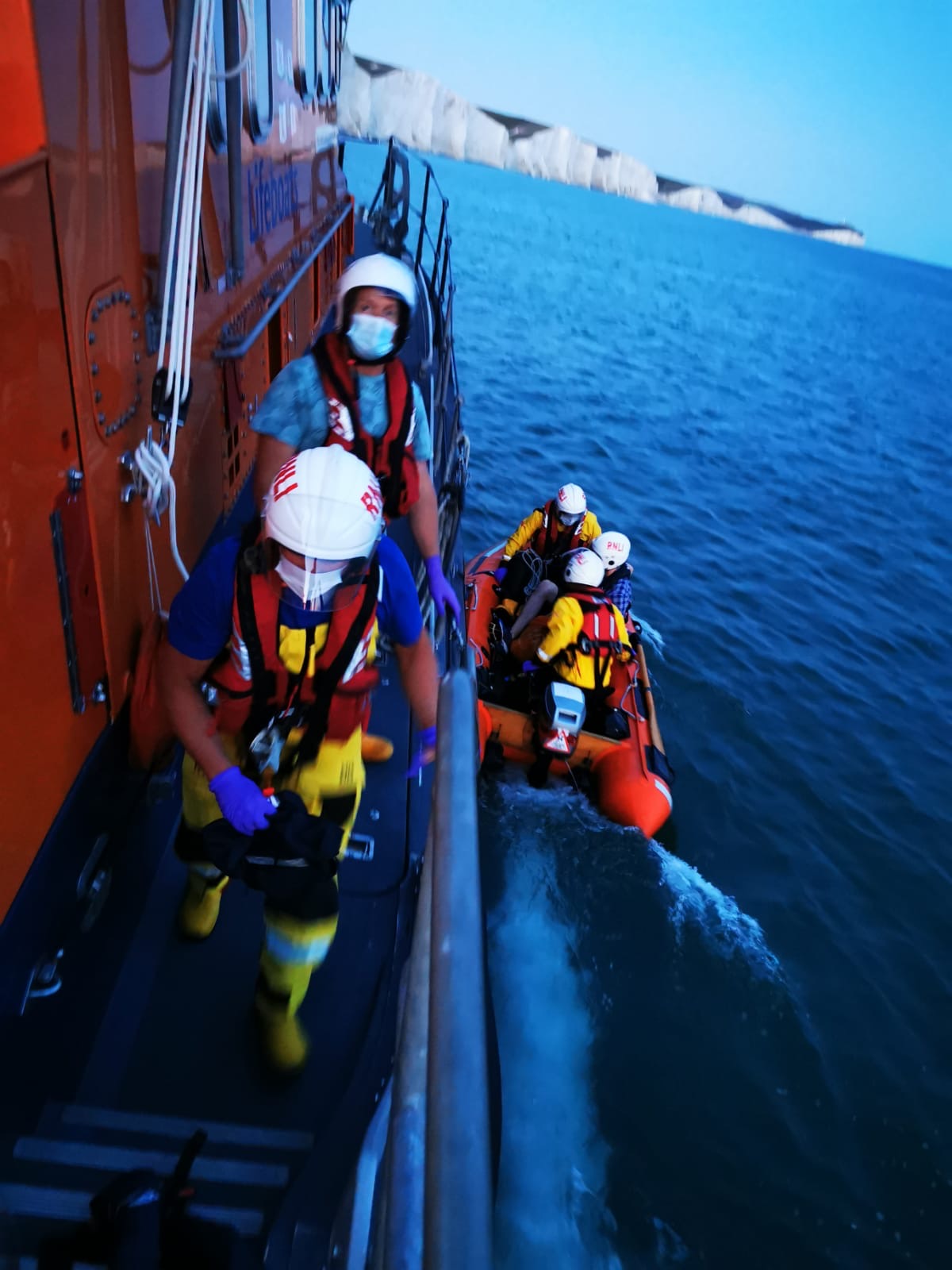 Newhaven crew and rescued casualties wearing PPE on board Severn class lifeboat and launched Y-boat.