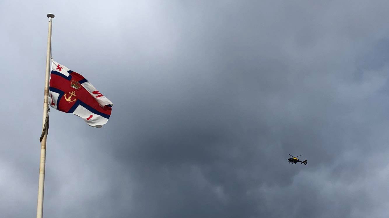 Police helicopter flying past RNLI flag 