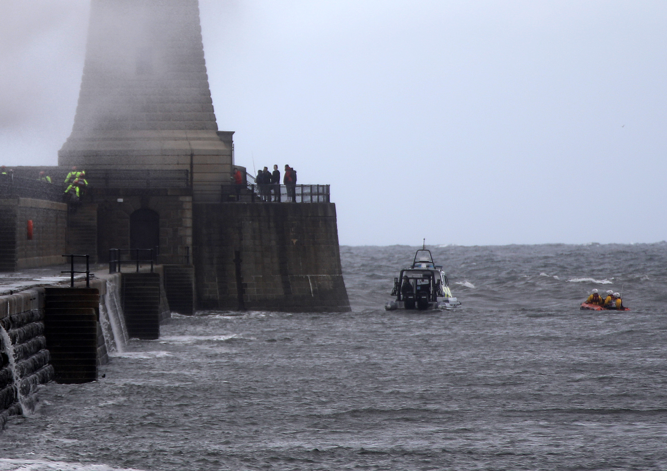 SIX men fishing from the end of Tynemouth pier sparked a major emergency services response on Sunday afternoon. This pic: Members of the TVLB (left, yellow safey suits) emerge from the tunnel to escort the fishermen from the pier as the police launch and Tynemouth RNLI inshore lifeboat stand off. 